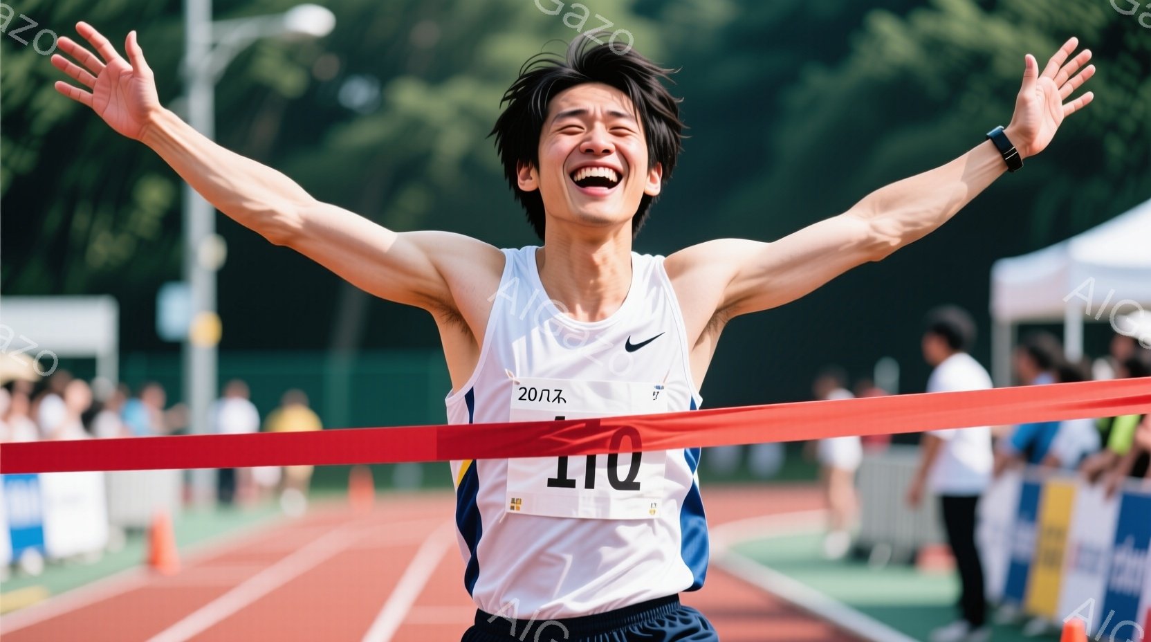 白いランニングシャツと黒い短パンを着用した若い男性が、フィニッシュラインを駆け抜け、両手を大きく広げて歓喜しています。彼の表情は笑顔で満ち溢れ、髪は短く整えられています。背景には緑豊かな自然と観客席が見え、晴天の下、競技場の活気を感じさせる一枚です。