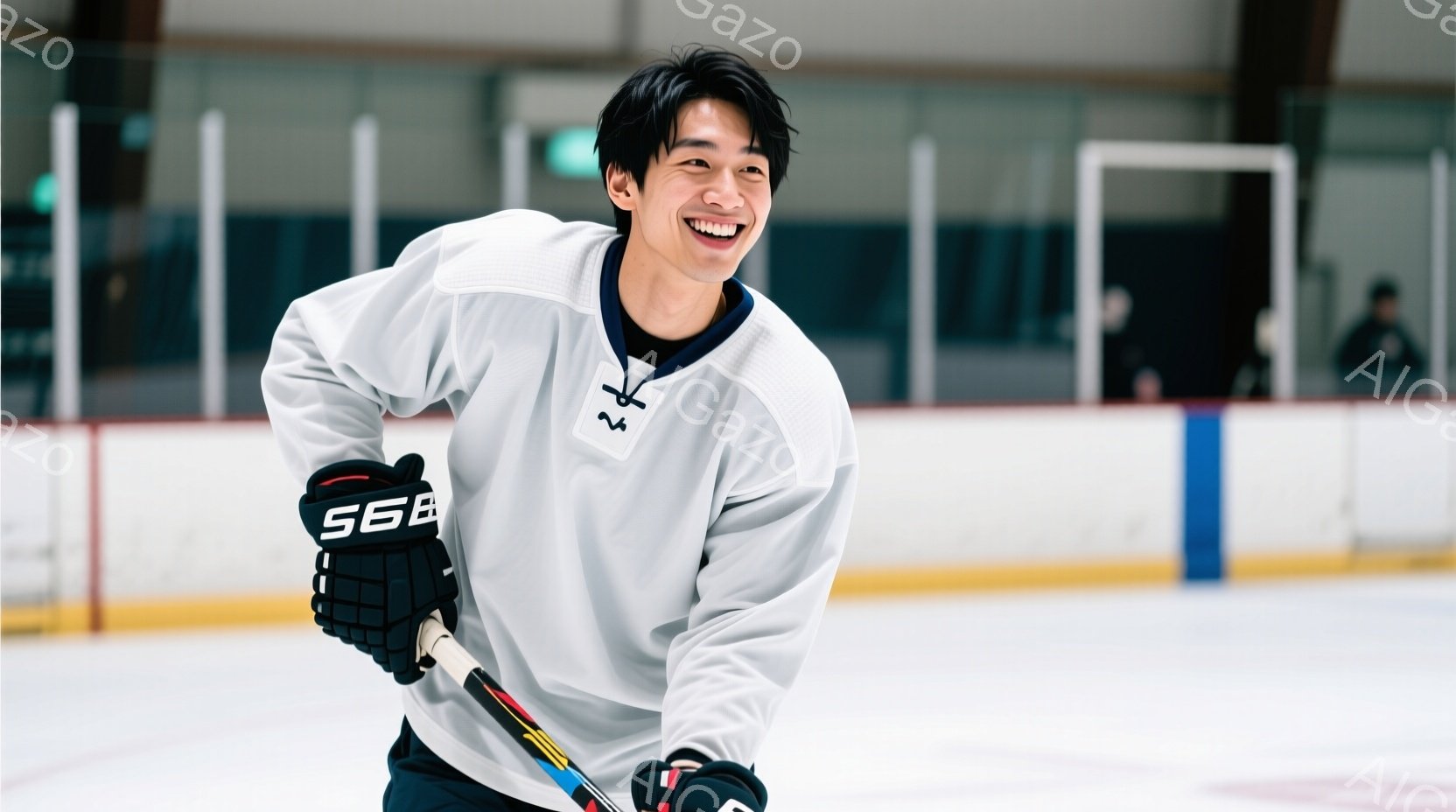 リンクの上にいる若い男性は、アイスホッケーのユニフォームとグローブ、ヘルメットを着用し、ホッケーのスティックを持っています。彼は明るい笑顔で、少し前かがみの姿勢で、まるで試合や練習に臨む直前のようです。背景はアイスリンクで、遠くにはぼんやりと人影が見え、全体的に活気のあるスポーツの雰囲気が漂っています。