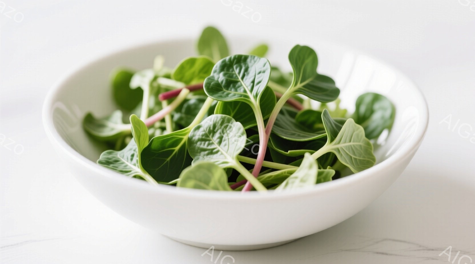 白いボウルに、赤茎の若葉野菜がたっぷりと盛り付けられています。葉は鮮やかな緑色で、全体的にフレッシュで健康的な印象を与えます。背景は白く、野菜の色を引き立てています。 - AI生成フリー素材