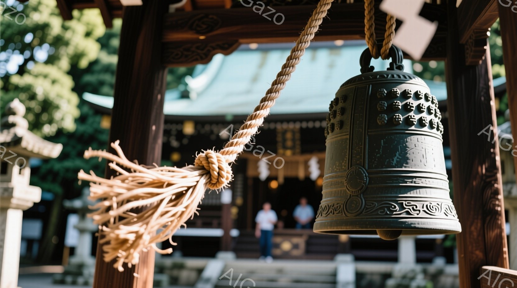 古い寺院の鐘が、木製の骨組みの中で吊り下げられています。鐘には細かい模様が彫られており、粗い麻紐で結ばれています。背景にはぼやけた寺院の建物と、数人の人が見え、穏やかで静寂な雰囲気を醸し出しています。