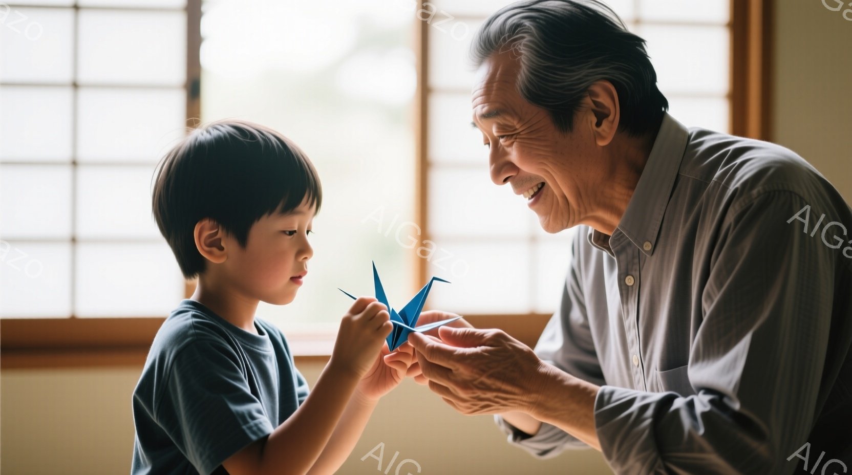 少年と高齢男性が折り紙の鶴を見つめ合っている。少年は青いTシャツを着ており、短髪で少し緊張した表情をしている。高齢男性はグレーのシャツを着て、穏やかな笑顔で鶴を少年に見せている。