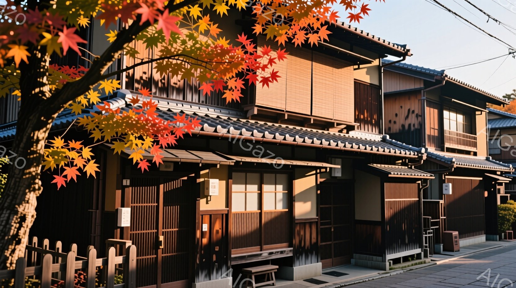 伝統的な木造建築が並ぶ、京都の風情ある街並みが見られます。建物は暗い茶色で、屋根は瓦葺きで、繊細な木製の格子が特徴的です。鮮やかな赤色の紅葉が建物の前に広がり、秋の訪れを告げており、全体的に落ち着いた、ノスタルジックな雰囲気が漂っています。