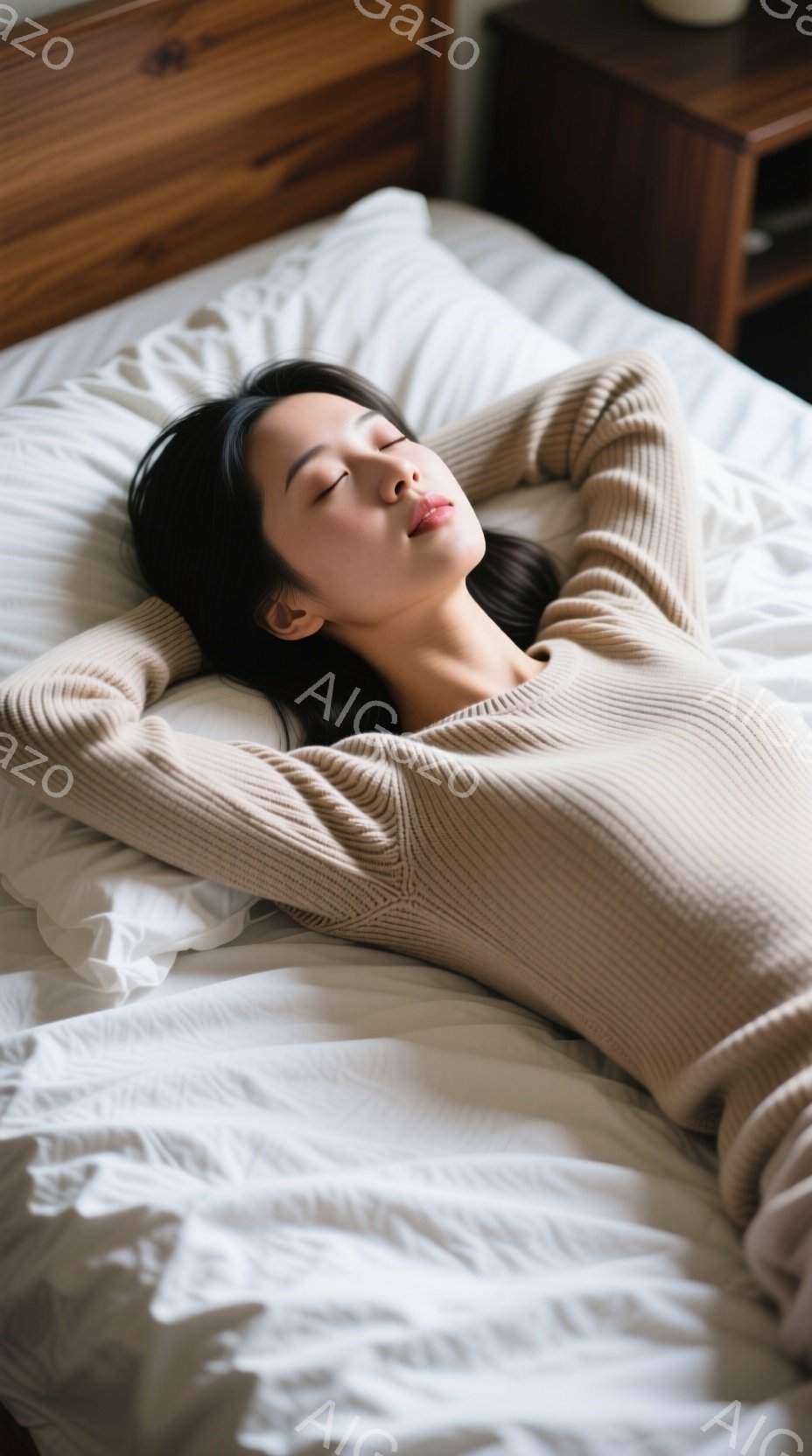 長い黒髪の女性が白いベッドの上で仰向けに寝ており、ベージュ色のニットセーターを着ています。彼女は目を閉じてリラックスした表情をしており、両腕を頭の後ろで組んでいます。背景には木製のナイトスタンドが見え、全体的に穏やかで静謐な雰囲気が漂っています。