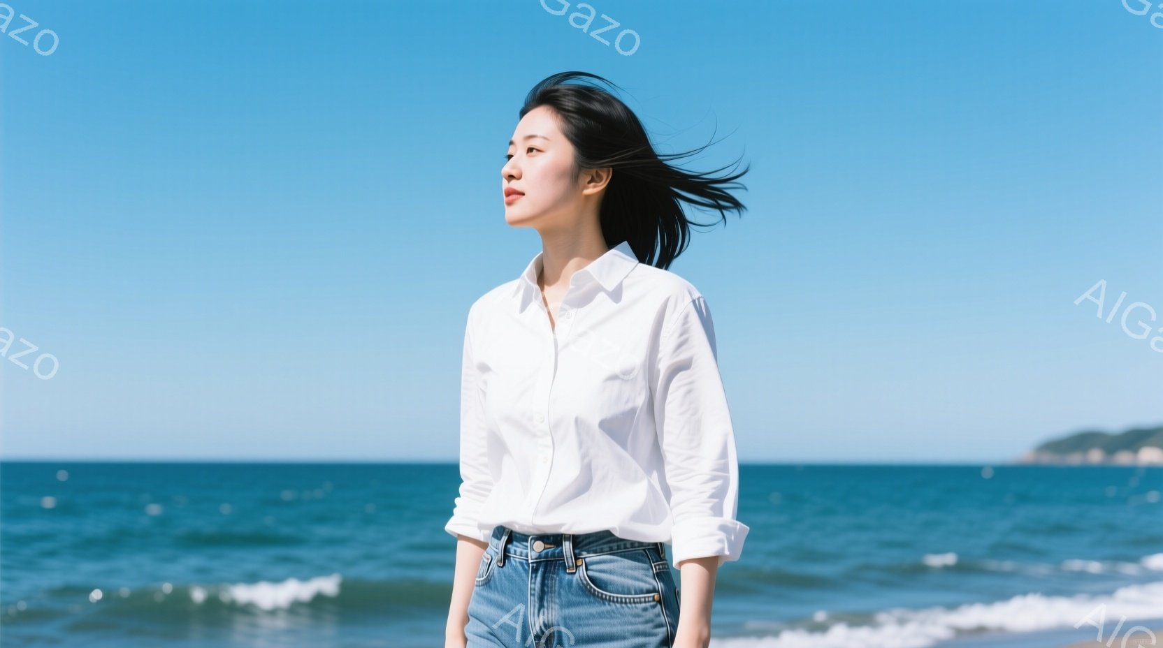 長い髪を風になびかせながら、女性が海岸線で立っている。白いシャツとデニムのジーンズを着ており、わずかに横を向いて遠くを見つめている。背景には青い海と空、そして遠くの緑の陸地が見え、晴れた日の爽やかな雰囲気が漂っている。