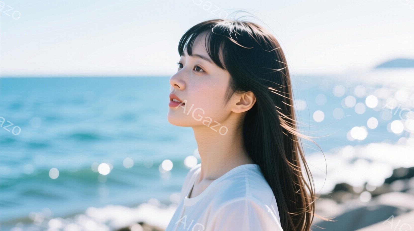 長い黒髪をなびかせ、白いシャツを着た若い女性が、横顔で海を見つめている。彼女の表情は穏やかで、どこか物思いにふけっているようにも見える。背景には青い海と白い波が広がり、晴天の下、穏やかな時間が流れている。