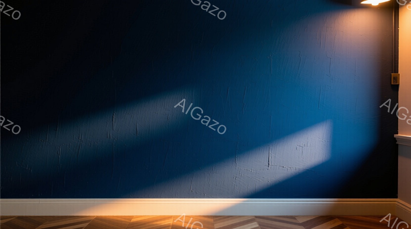 深い青色のテクスチャード壁に、強い光が斜めに差し込み、ドラマチックな影を作り出している。床はヘリンボーン状の木製フローリングで、壁の下部には白いモールディングが施されている。全体的に静かで、現代的であ - AI生成フリー素材