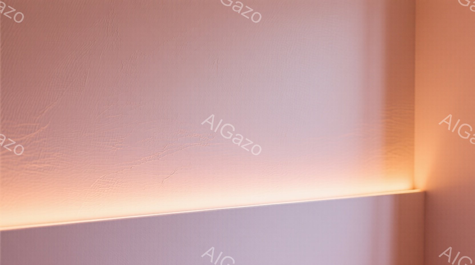 壁一面にオレンジ色の間接照明が照らされ、壁のテクスチャが強調されています。光は水平方向に広がり、壁に柔らかい影を落としています。全体的に暖かく落ち着いた雰囲気で、ミニマルな空間を演出しています。