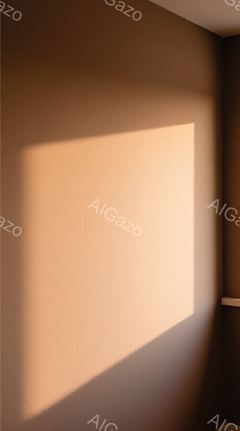 部屋の壁一面が、温かいベージュ色で塗られています。壁には、太陽光が差し込み、四角い影が落ちています。全体的に、静かで落ち着いた、穏やかな雰囲気が漂っています。