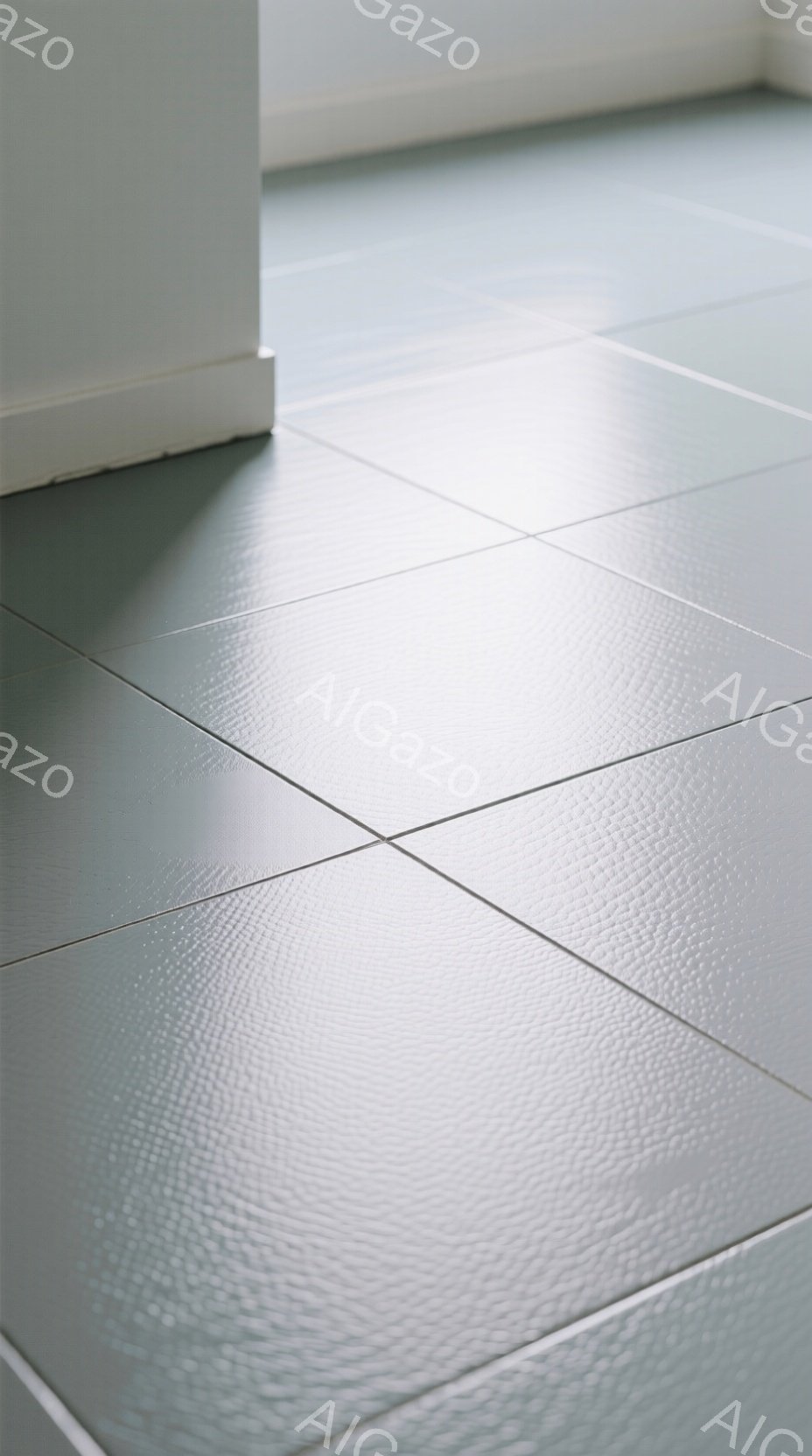 画像は、淡い緑色のタイルが敷き詰められた床の一部を捉えている。タイルの表面はわずかにテクスチャがあり、光沢があるように見える。背景には白い壁の一部が見え、シンプルで落ち着いた雰囲気を醸し出している。