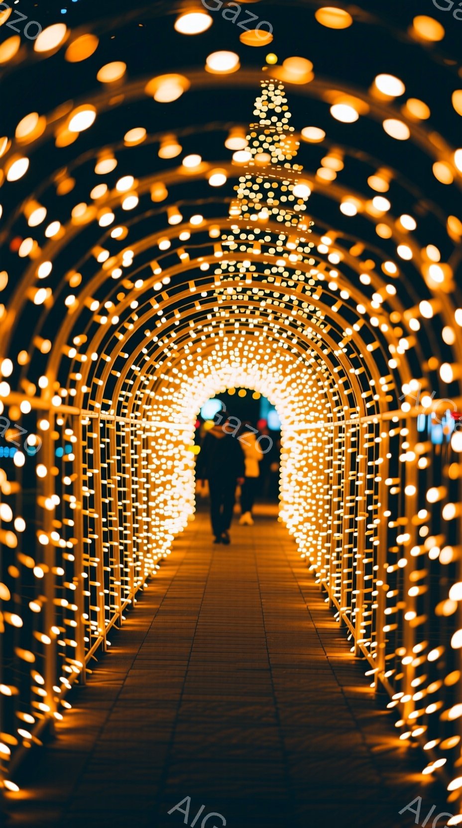 輝く電球でできたアーチが、まるでトンネルのように続いている夜の風景だ。アーチの中を二人の人物が歩いており、シルエットのため服装や表情ははっきりしないが、リラックスした姿勢でゆっくりと進んでいる様子が伺える。背景は暗く、アーチの光が強く照らし出すことで、幻想的で温かい雰囲気が漂っている。
