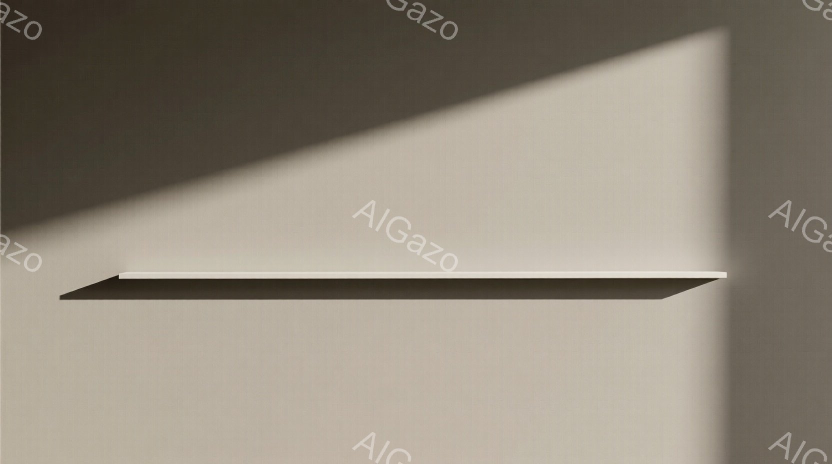 この画像は、壁に取り付けられた白い棚を捉えています。棚の上には何も置かれておらず、壁に影が落ちています。全体的にミニマリストで、穏やかで静けさのある雰囲気です。