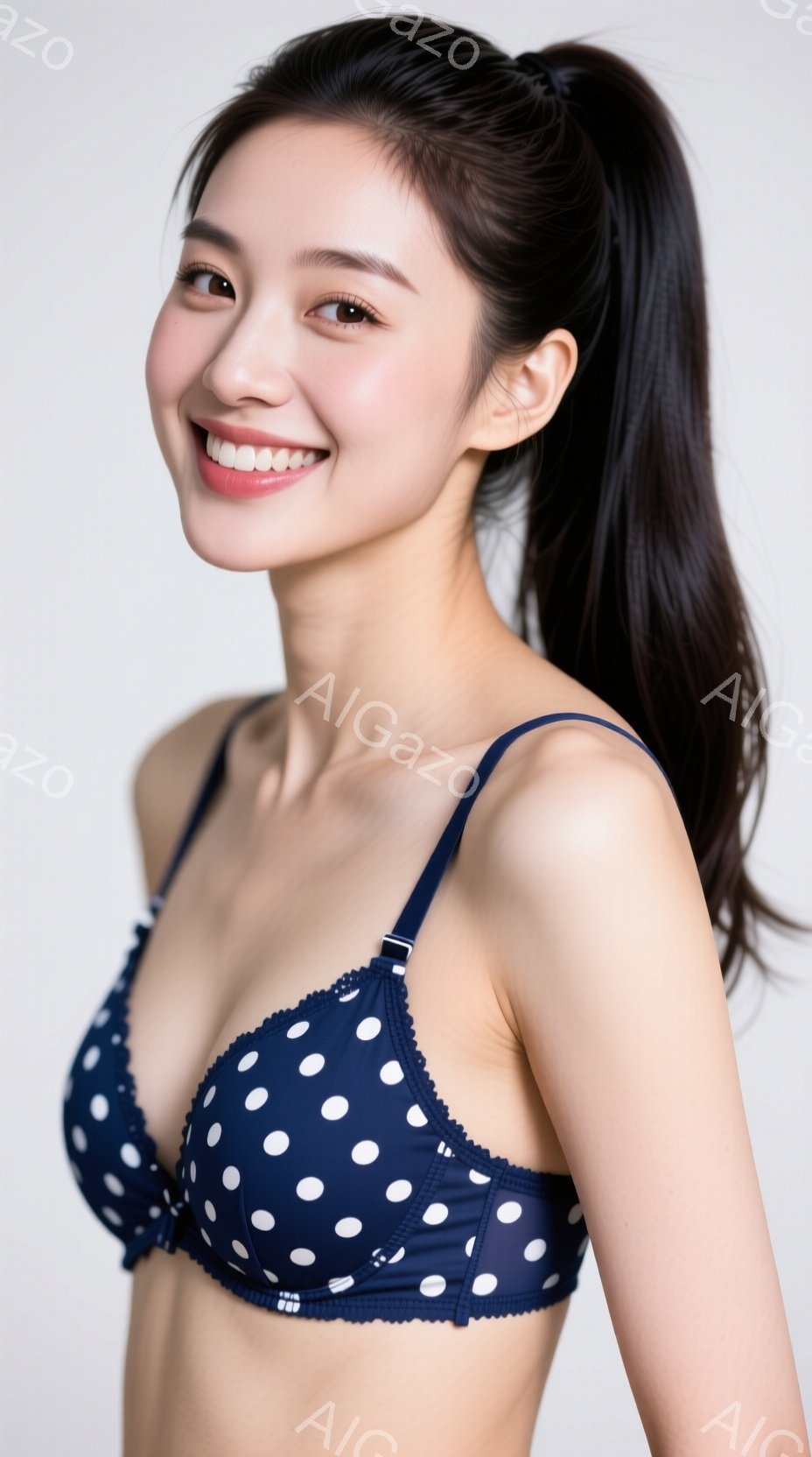 深い青色の水玉模様のブラレットを着た女性が写っています。彼女は長い黒髪を後ろでポニーテールにし、微笑んでいます。背景は白く、女性に焦点が当てられています。 - AI生成フリー素材
