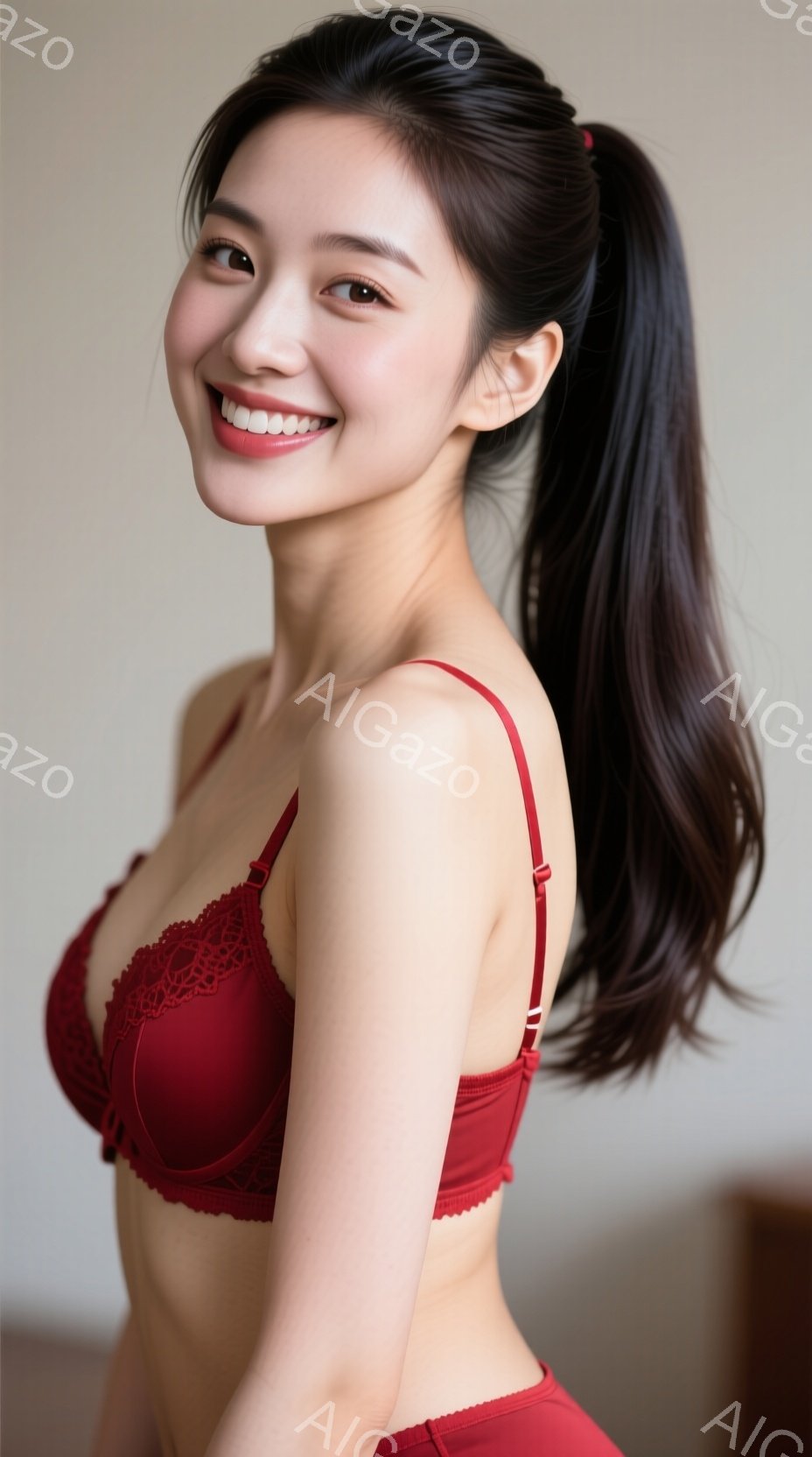 長い黒髪をポニーテールにし、赤いブラとショーツを身に着けた若い女性が写っています。彼女は微笑んでおり、姿勢はリラックスしています。背景はぼやけていますが、白い壁とわずかな影が見えます。