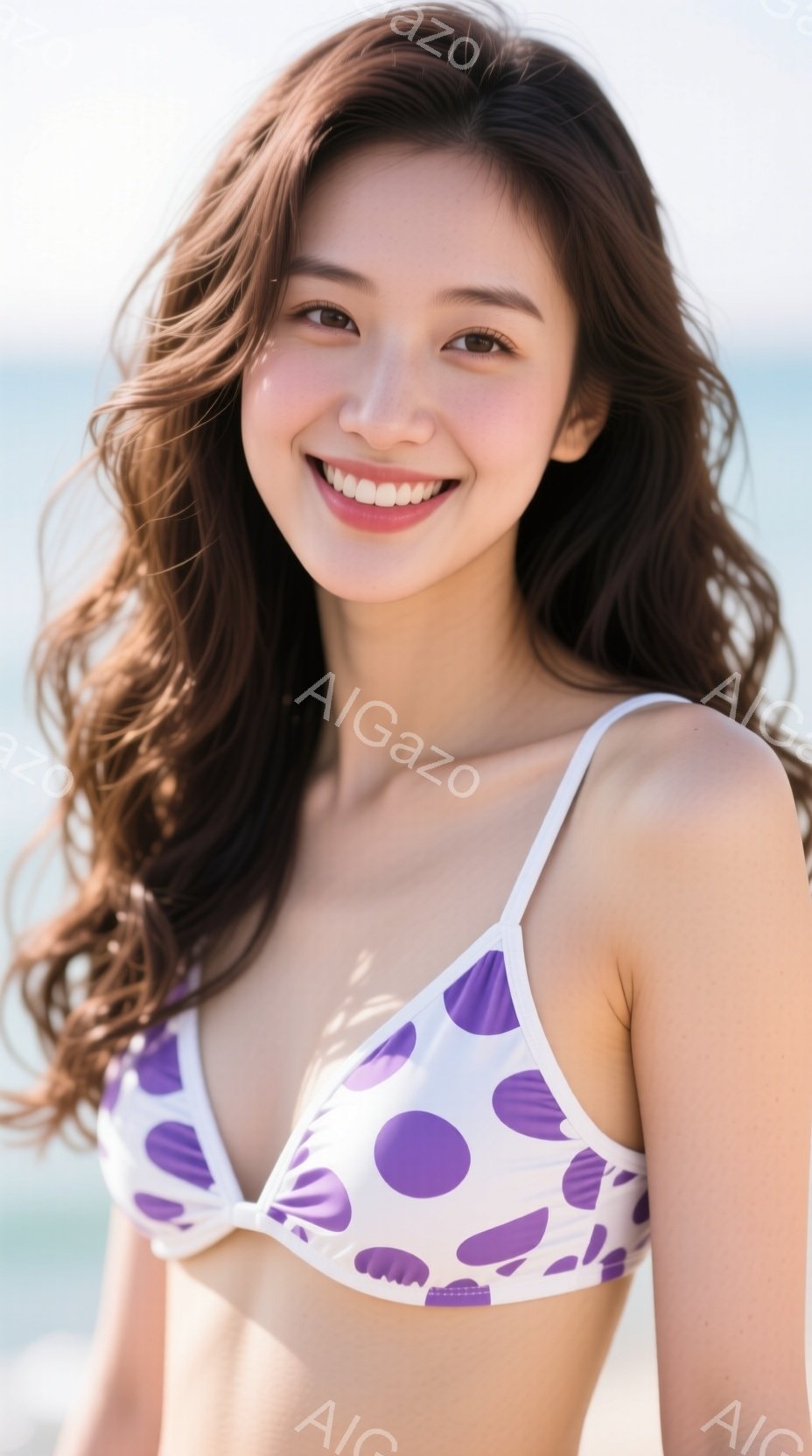 長い茶色の巻き髪が風になびき、白い水玉模様のビキニトップスを着た女性が写っています。彼女は明るい笑顔を見せ、視線をカメラに向けています。背景には穏やかな海と青空が広がり、夏の陽気な雰囲気が漂っています。