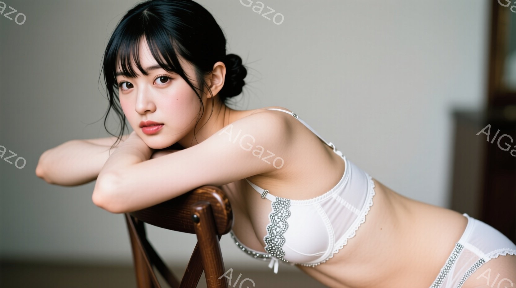 長い黒髪で前髪が目にかかる女性が、白いレースのブラとショーツ姿で椅子にもたれかかっています。彼女は肘を曲げて膝の上に手を置き、少し物憂げな表情をしています。背景は薄い壁で、室内で撮影された、静かで官能的な雰囲気の写真です。