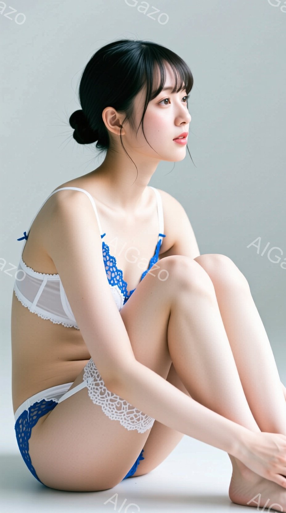 白い背景を背景に、若い女性が青いレースのトリミングが施された白いランジェリーを着て座っています。彼女は足を抱え、少し上目遣いでどこか見つめているような表情をしています。髪は肩までの長さで、前髪が目にかかり、全体的に繊細で落ち着いた雰囲気を醸し出しています。