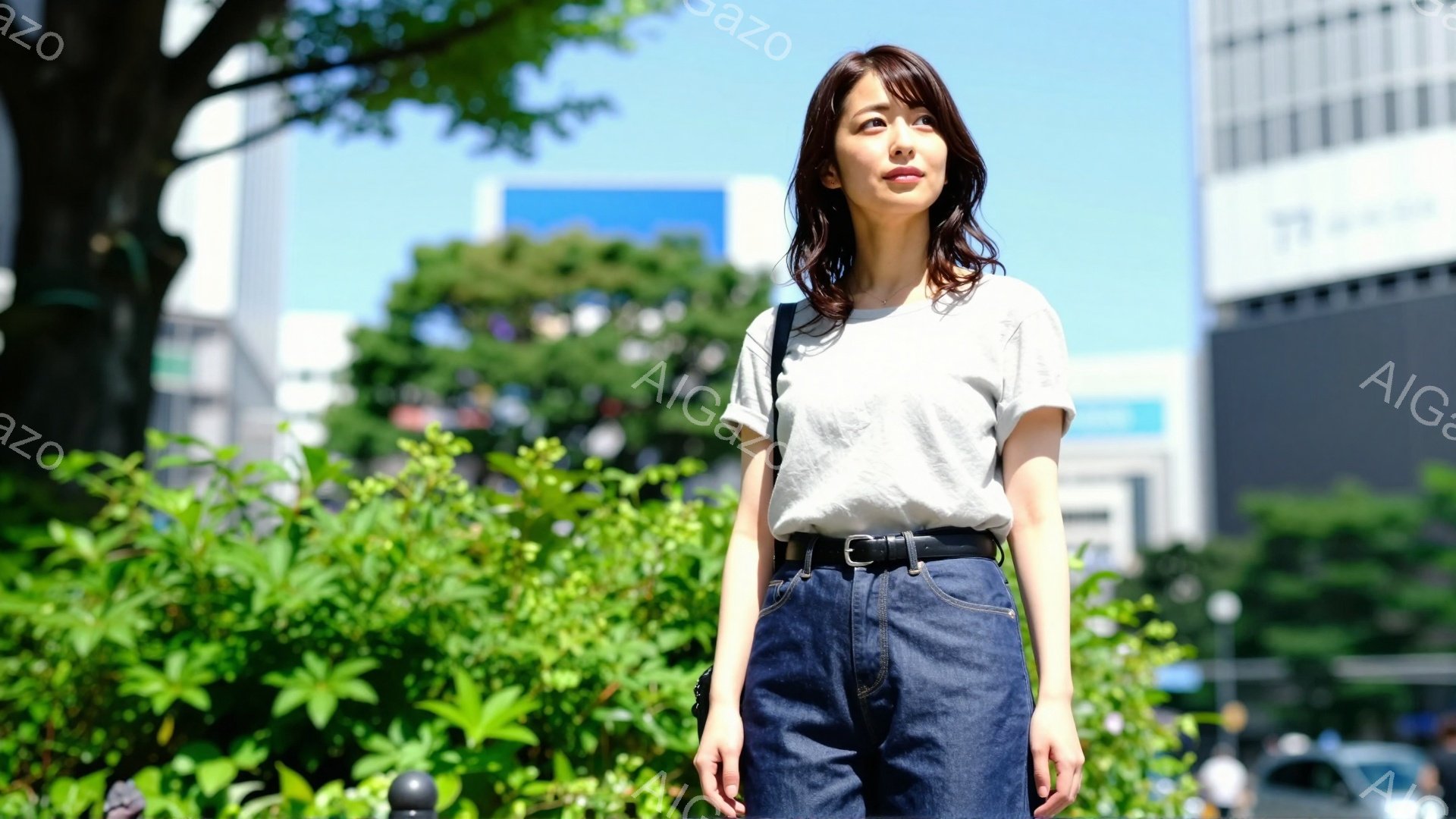 画像には、グレーのTシャツとデニムのオーバーオールを着た若い女性が写っています。彼女は少し上を見上げており、穏やかでわずかに微笑んだ表情をしています。背景には緑豊かな植物と高層ビルが見え、晴れた日の屋 - AI生成フリー素材