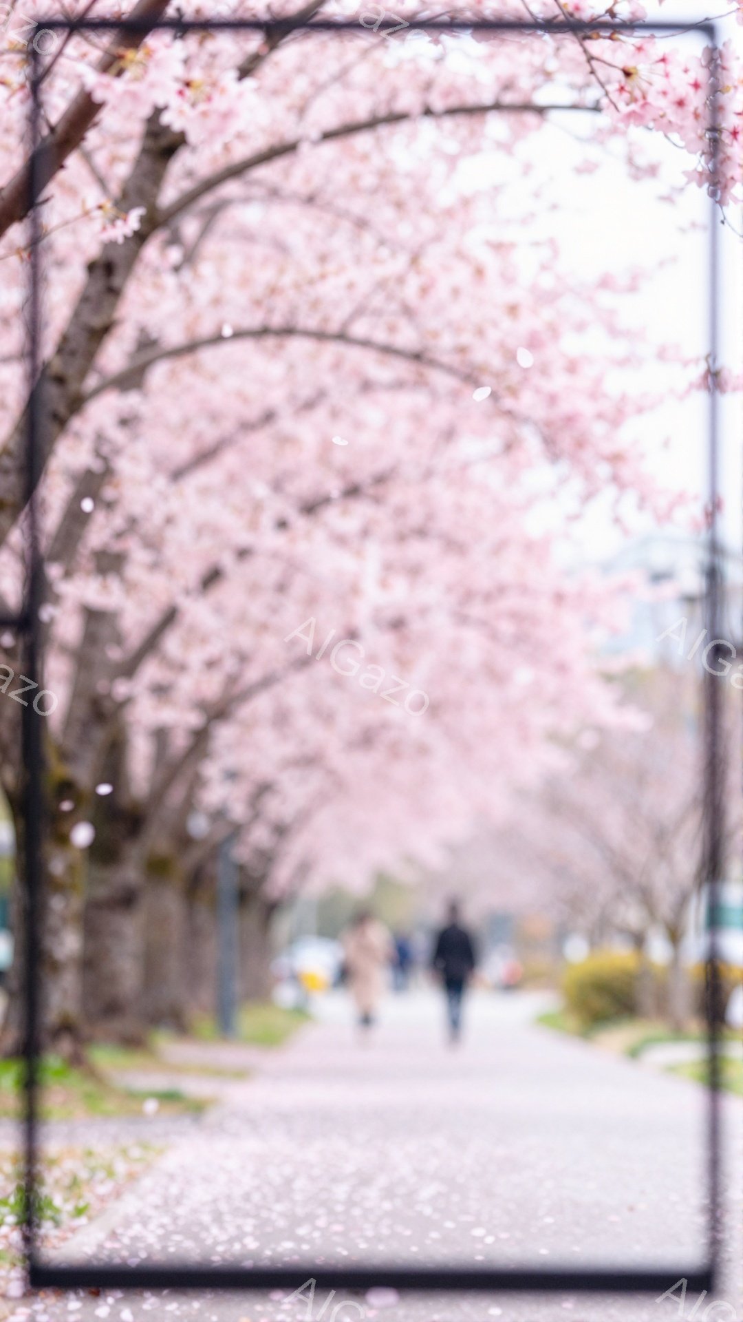 桜並木の中を数人の人々が歩いている様子が捉えられている。手前の人物は黒いコートを着ており、奥にはベージュ色のコートを着た人物が見えるが、顔や表情はぼやけて特定できない。桜の花びらが舞い散り、春の穏やかな陽気を感じさせる、幻想的な雰囲気である。