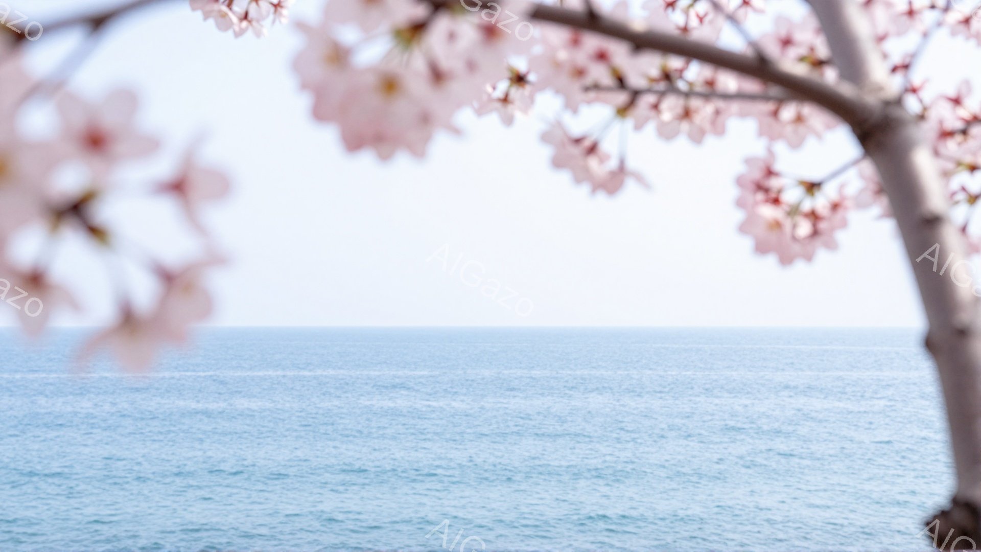 桜の花びらが前景を彩り、遠くには穏やかな青い海が広がっている。太陽光が海面に反射し、キラキラと輝いている様子が春の穏やかさを象徴している。全体的に柔らかな色合いで、安らぎと希望を感じさせる風景である。