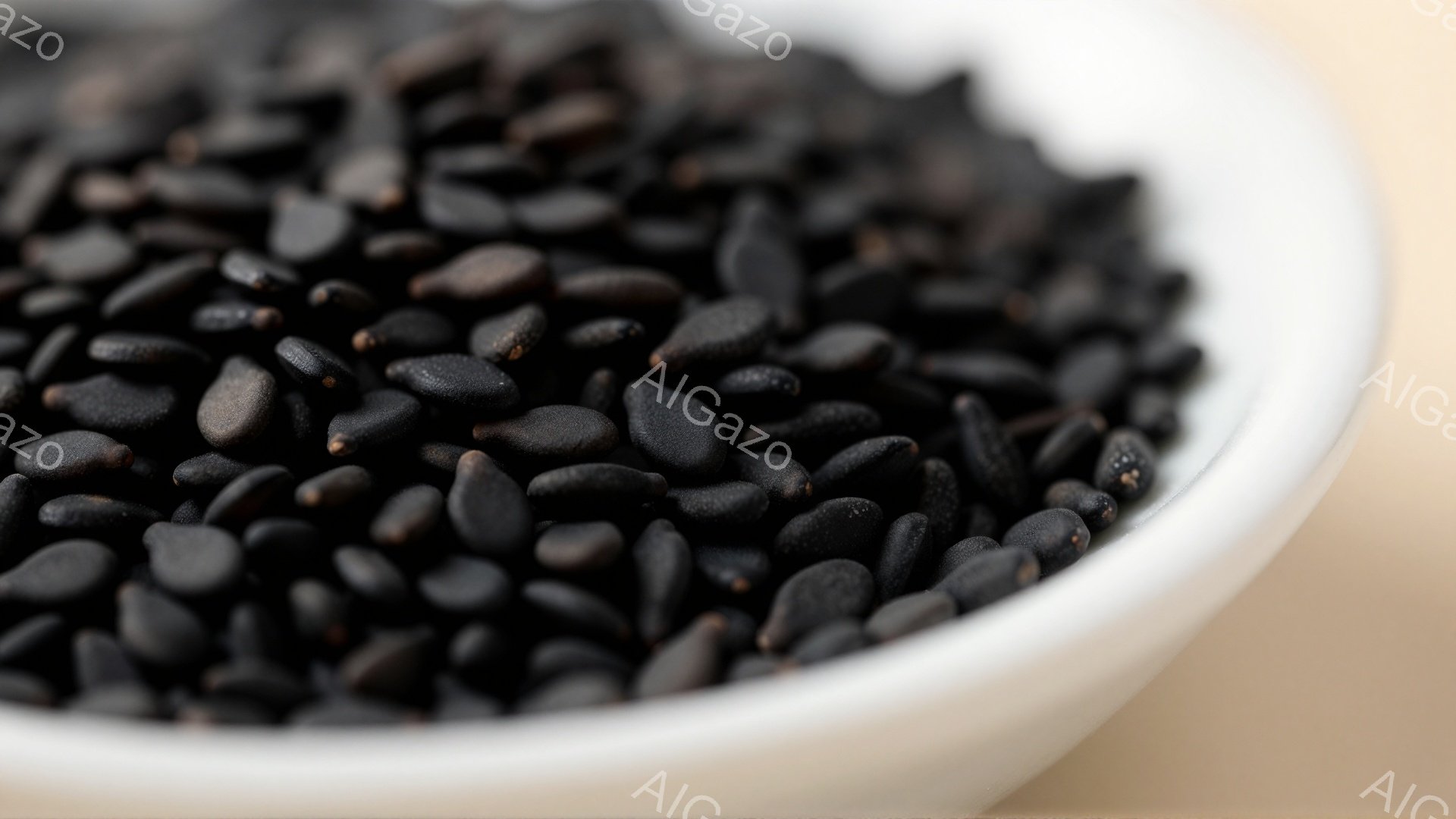 白い器の中に黒ごまがたっぷりと入っています。黒ごまは細長く、密集して配置され、光沢があり、全体的に落ち着いた雰囲気を醸し出しています。背景はぼやけており、黒ごまが際立って見えます。