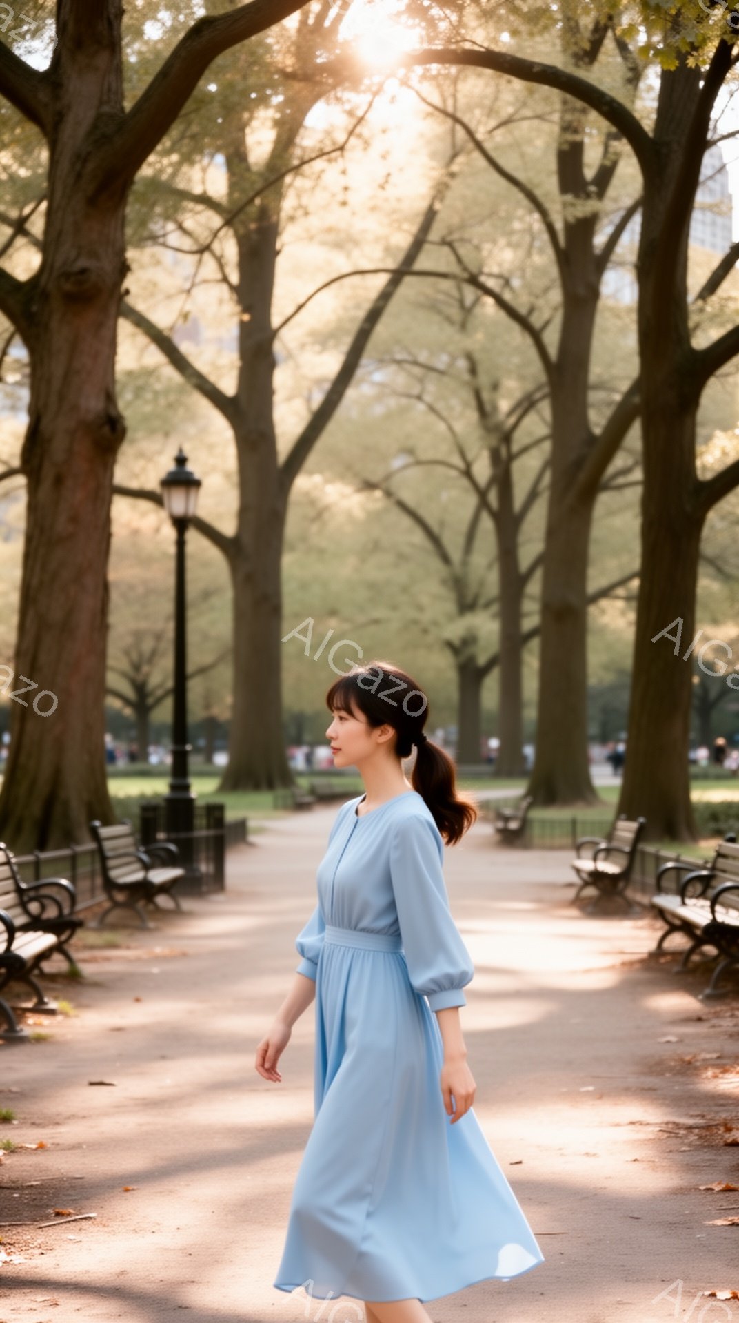 明るい水色のワンピースを着た女性が、公園の遊歩道を歩いている。彼女は髪を後ろで一つにまとめ、穏やかな表情で遠くを見つめている。背景には緑豊かな木々とベンチが並び、太陽の光が差し込む晴れた日の穏やかな雰 - AI生成フリー素材