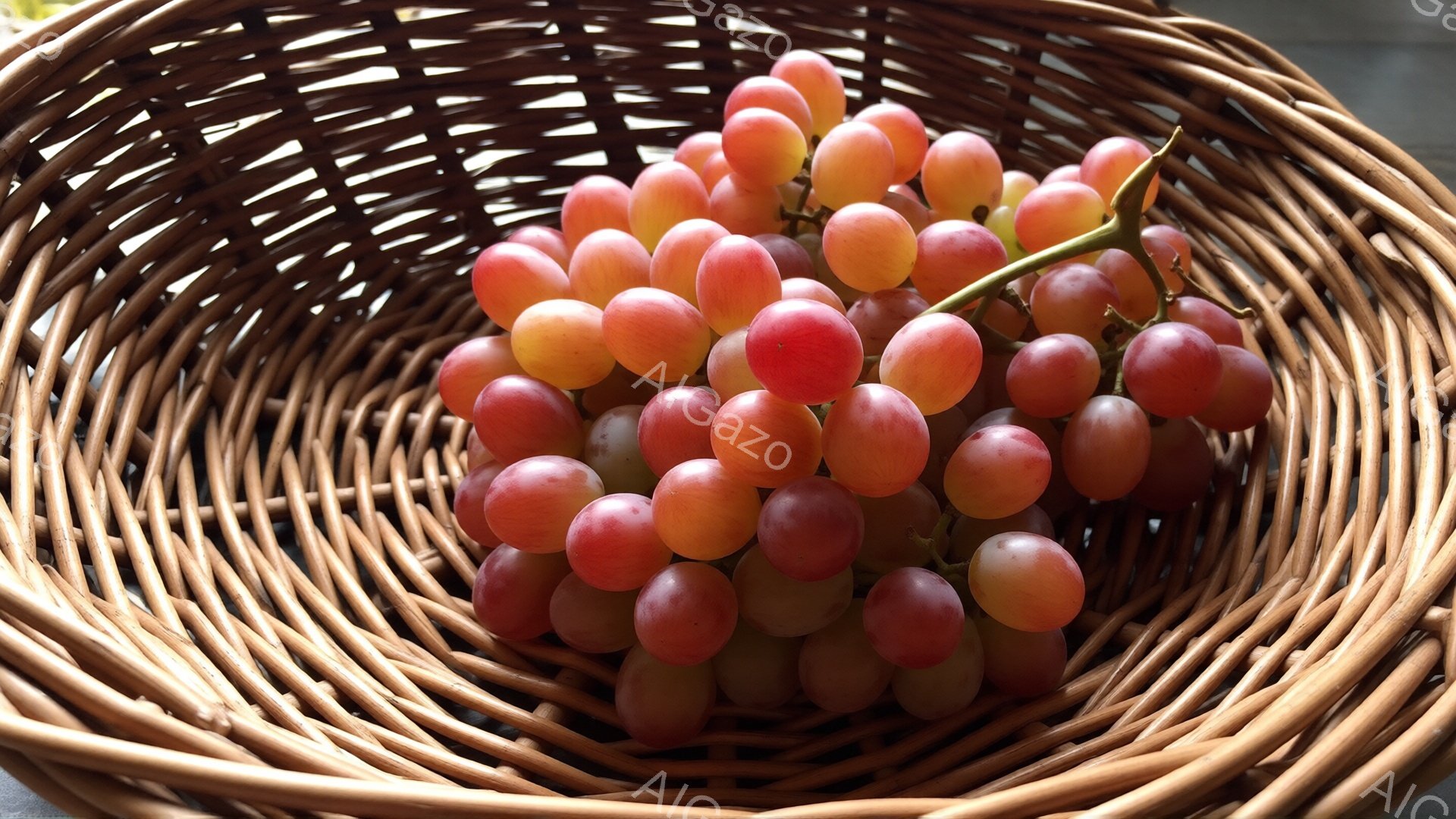 籐編みの籠の中に、赤紫色のブドウが山のように盛られています。ブドウは瑞々しく、光沢があり、まるで宝石のように見えます。籠の編み目が隙間なく続き、ブドウの豊かな色彩を際立たせています。 - AI生成フリー素材