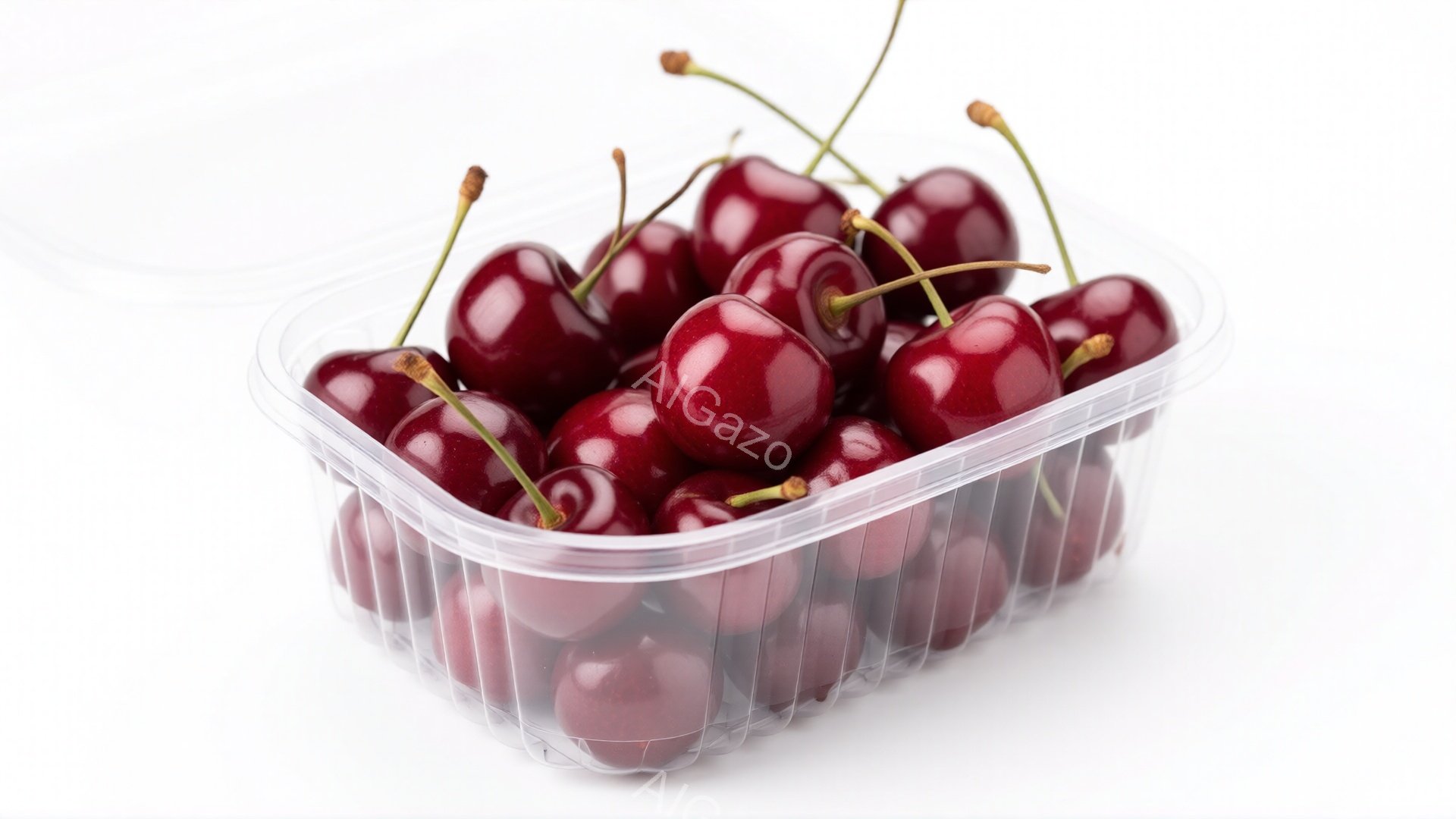 透明なプラスチックの容器に、深紅色のさくらんぎがぎっしりと詰まっています。果実はみずみずしく、光沢があり、一つ一つが丁寧に並べられています。背景は白く、さくらんぎの鮮やかな色が際立っています。