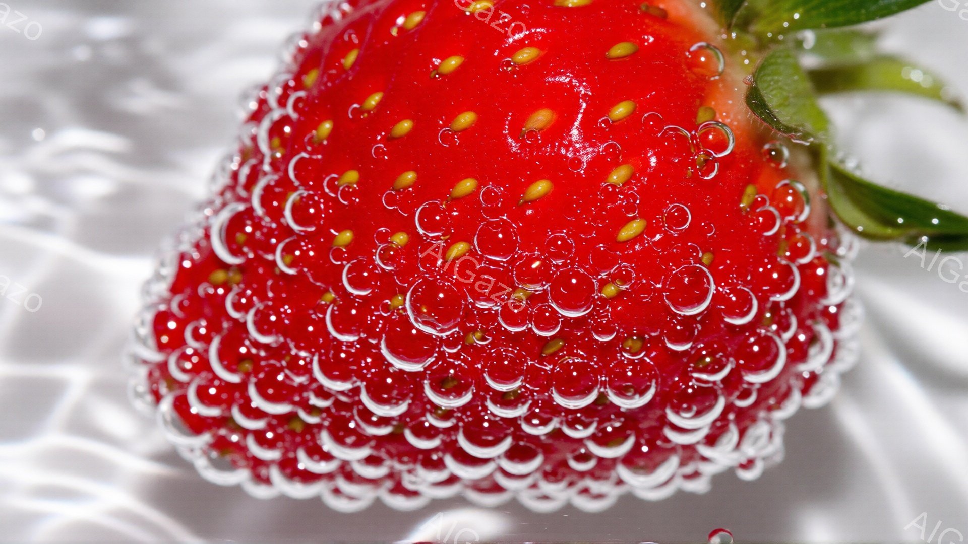 赤く熟したイチゴが、水滴で覆われているクローズアップ写真です。表面には小さな種が散りばめられ、透明な水滴がまるで宝石のように輝いています。背景はぼやけており、水しぶきのようなものが確認でき、全体的に爽やかで新鮮な印象を与えます。