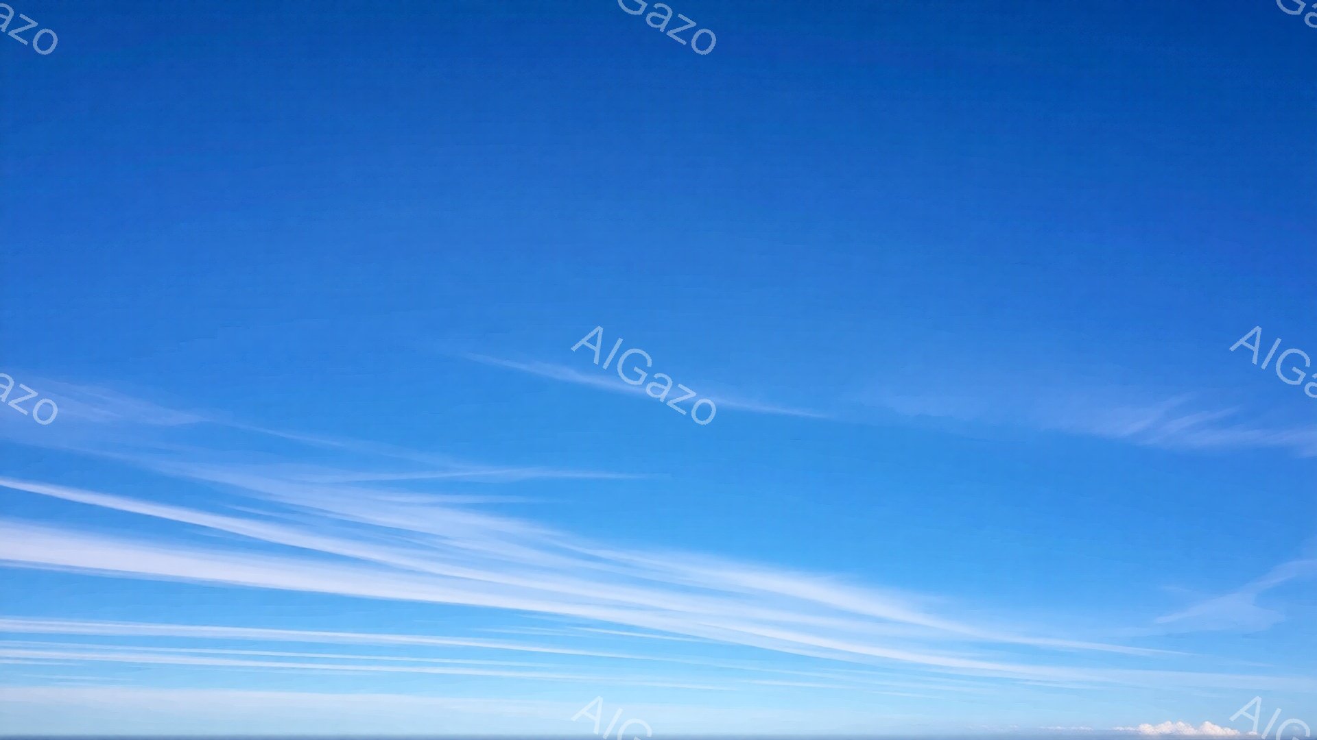 広大な青空に、白い筋状の雲が幾重にも広がっています。地平線付近にはぼんやりとした山の稜線が見え、空全体が澄み切った爽やかな印象を与えます。飛行機雲が空を横切り、静かで穏やかな夏の日の雰囲気を表現しています。