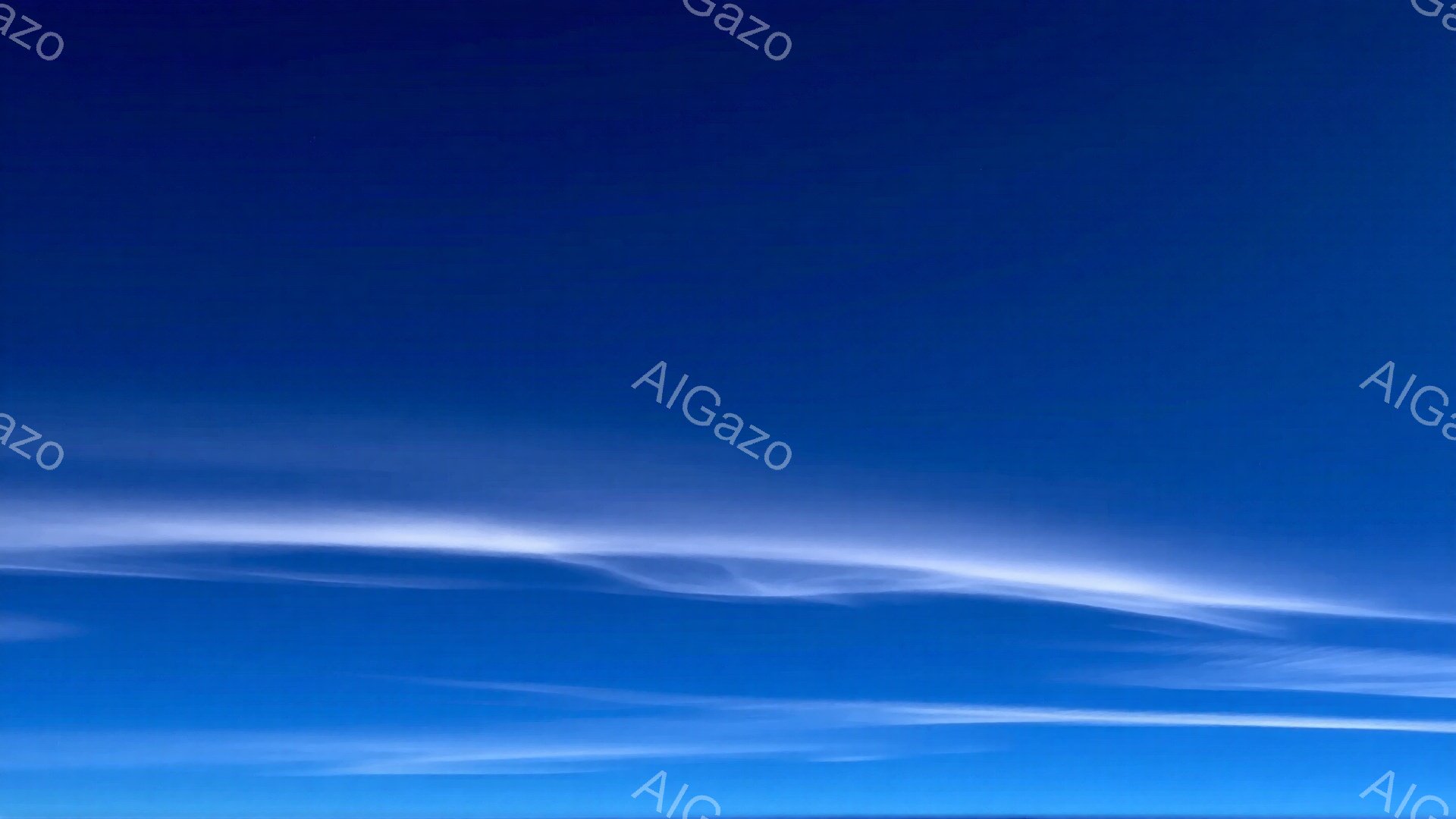 鮮やかな青空に、薄い白い雲が横に長く広がっています。雲はまるで筆で描いたような流れるようなラインを描き、空全体に穏やかな印象を与えています。全体的に晴れ渡った空で、平和で静寂な雰囲気が感じられます。