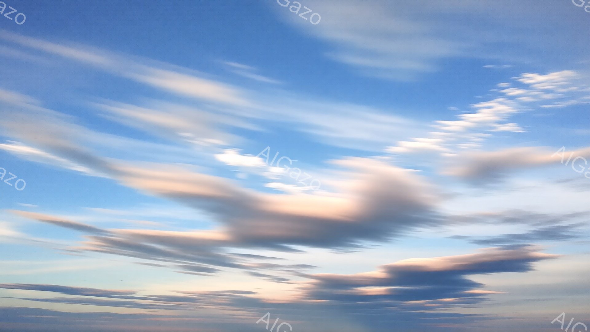 広大な青空に、淡いピンク色とグレーの雲が流れています。雲はまるで羽のような形をしており、太陽の光を浴びてほのかに輝いています。穏やかで幻想的な雰囲気で、空全体が優しい色彩に包まれています。 - AI生成フリー素材