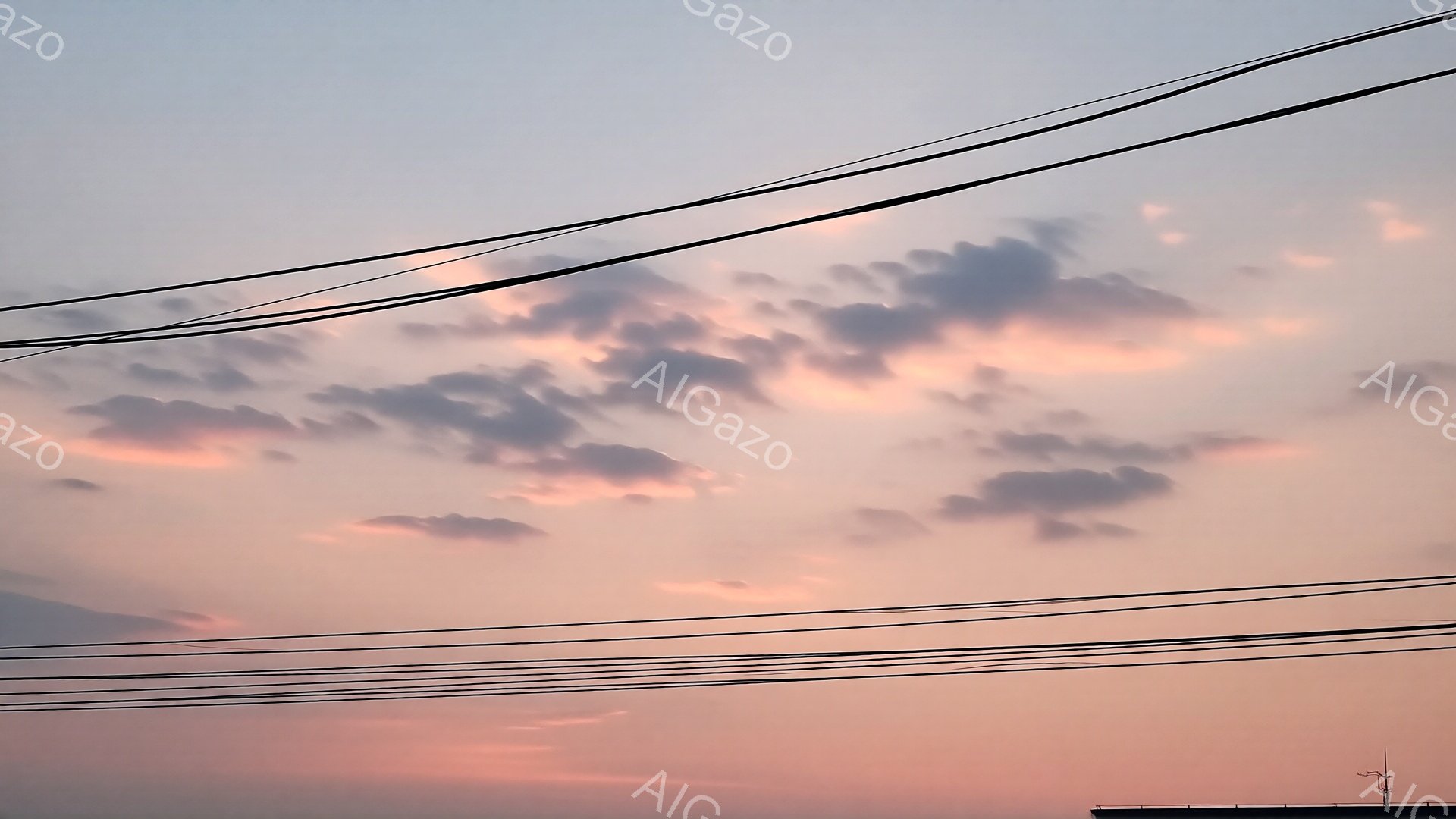 空は夕焼けの名残で、淡いピンクとオレンジ色が混ざり合い、雲がその色を反射して美しいグラデーションを作り出している。電線が画面の手前に走り、その向こうに屋根がわずかに見える。全体的に穏やかで、静けさを感 - AI生成フリー素材