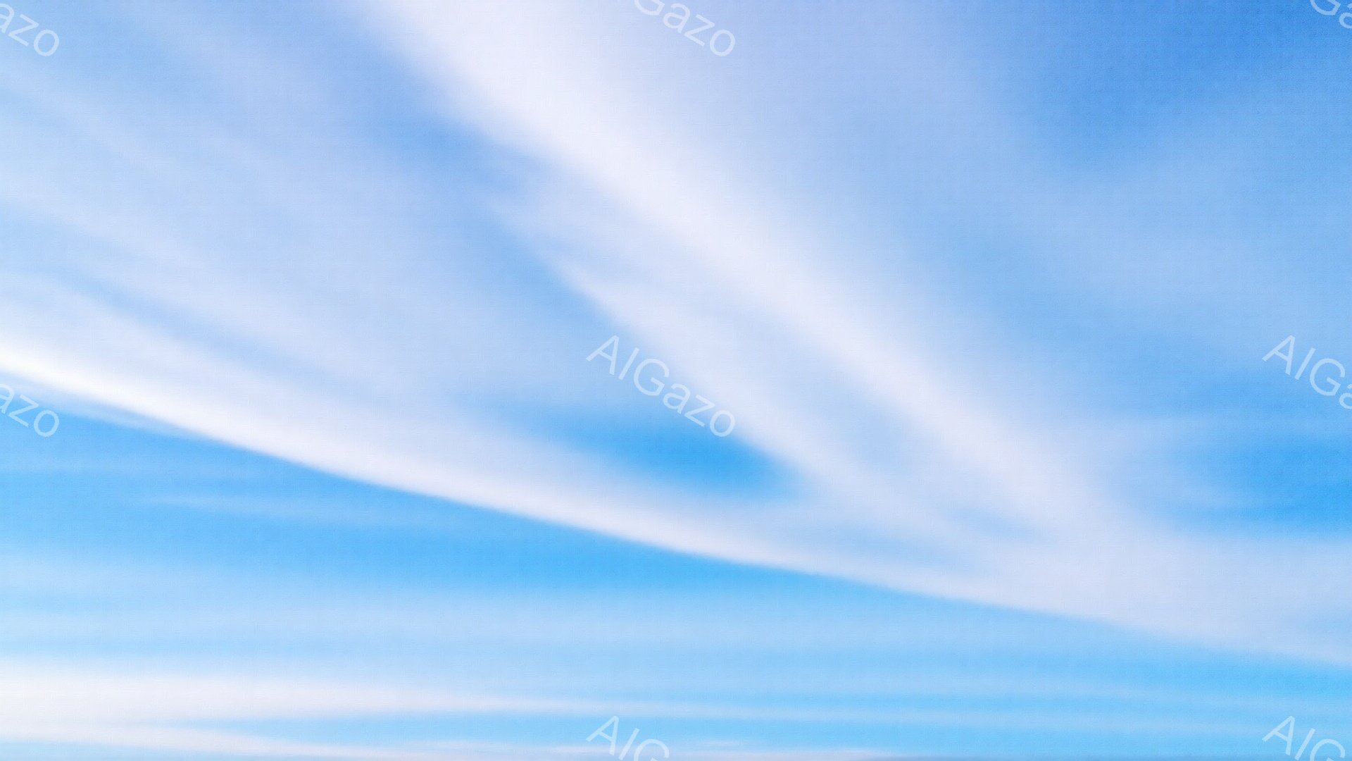 広大な青空に、白い筋状の雲が幾本か流れています。雲はまるで筆で描いたような、流れるような曲線を描き、空全体に広がっています。明るく爽やかな空模様は、平和で穏やかな雰囲気を醸し出しています。