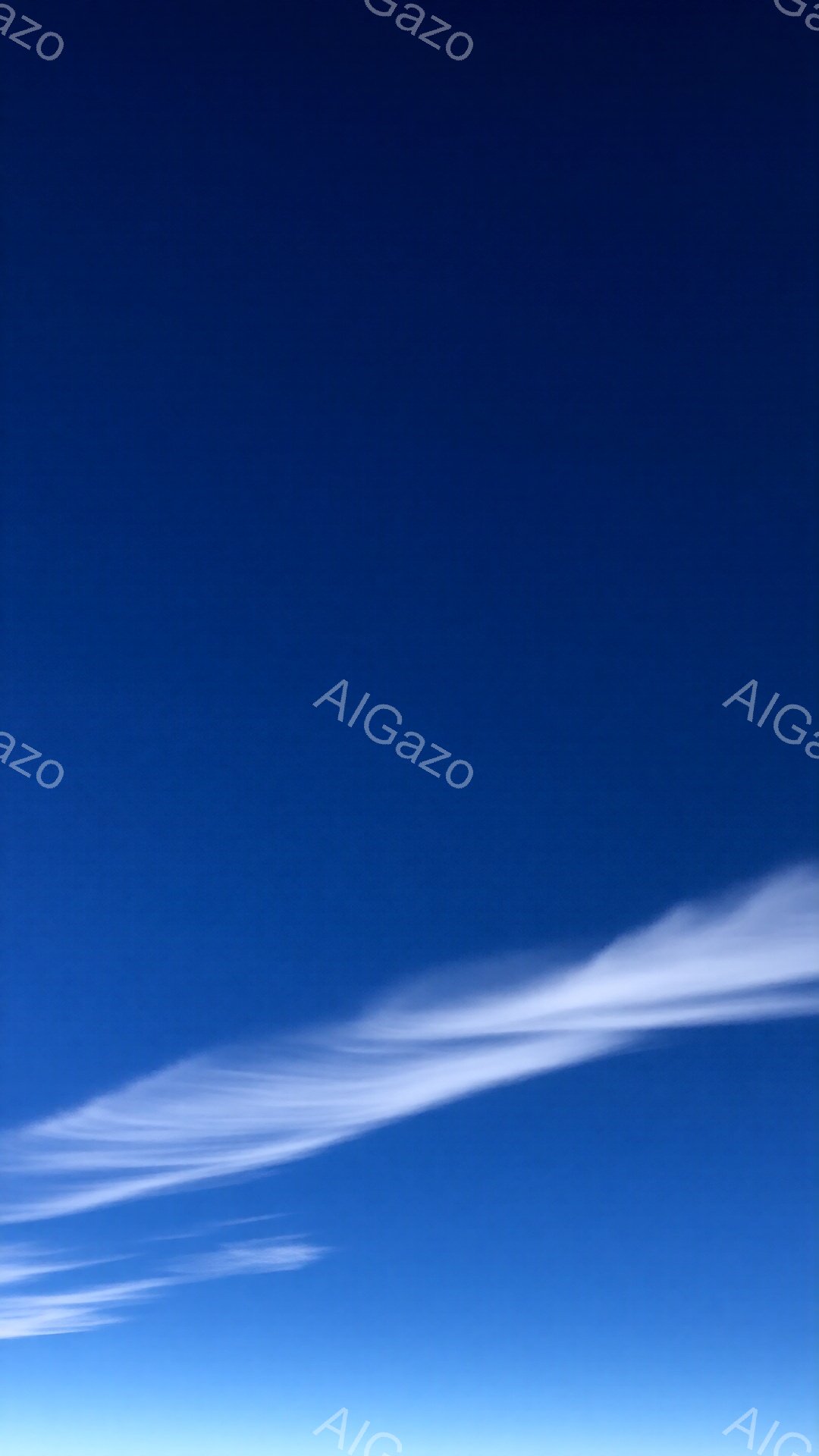 空は鮮やかな青色で、白い筋状の雲が水平方向に広がっています。雲はまるで筆で描かれたような繊細な曲線を描き、空の青さと美しいコントラストを生み出しています。全体的に晴れやかで穏やかな雰囲気が漂う、静謐な空模様です。