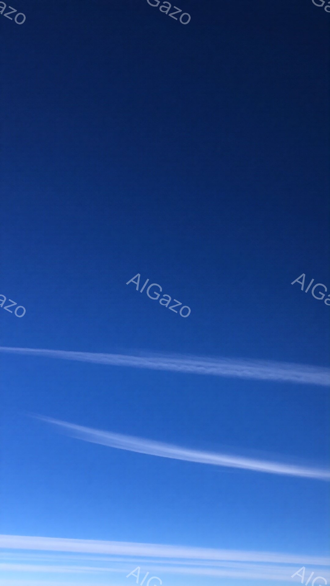 鮮やかな青空に、白い筋状の雲が数本、水平方向に伸びています。雲は薄く、まるで空を撫でるような繊細なラインを描いています。全体的に澄んだ空気を感じさせる、爽やかで穏やかな雰囲気です。