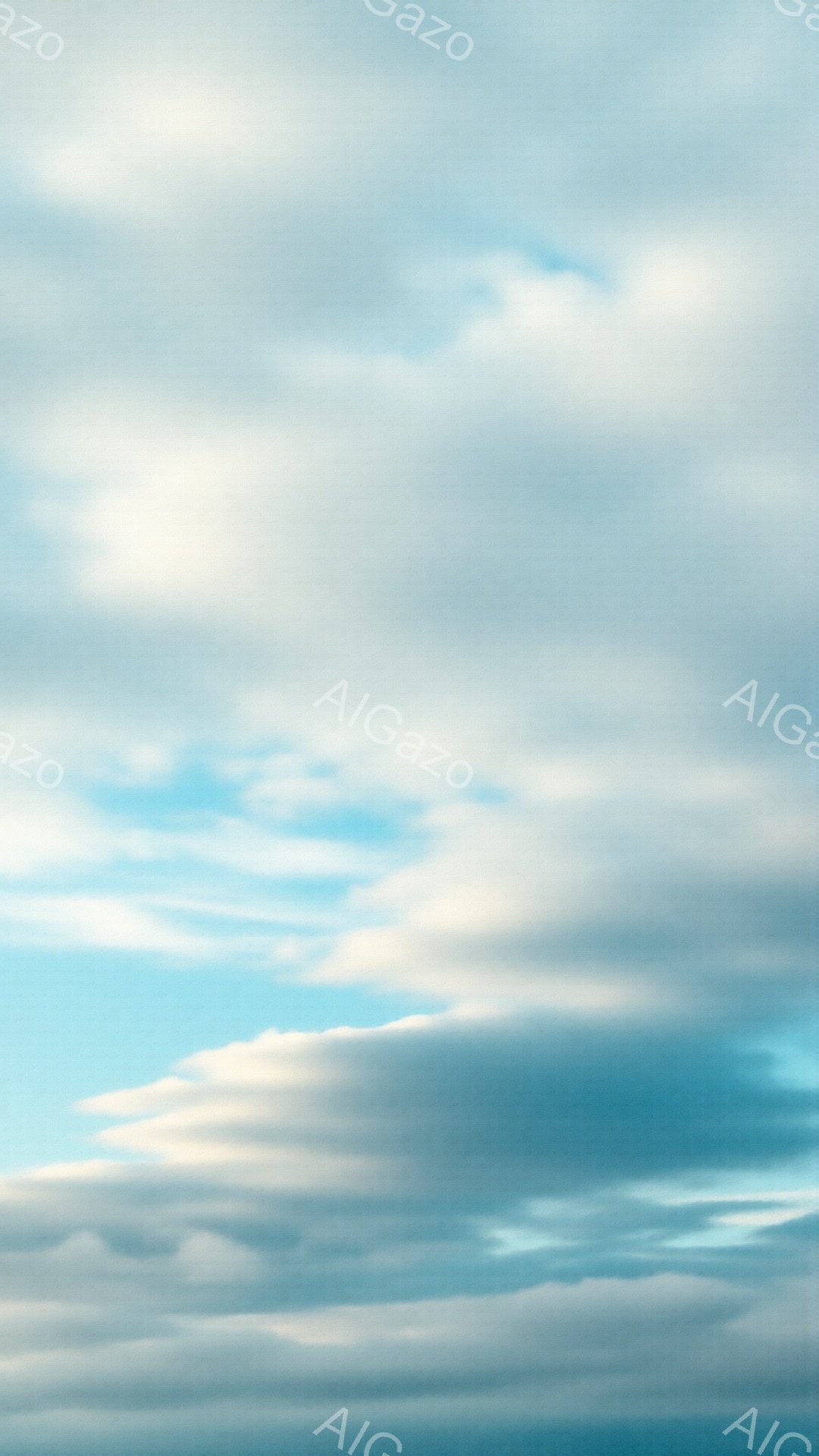 鮮やかな青空に、白と灰色の雲が広がり、まるで波のような形を描いています。雲の層は重なり合い、空全体に奥行きと動きを与えています。穏やかで静かな雰囲気が漂い、晴れた日の自然の美しさを感じさせます。