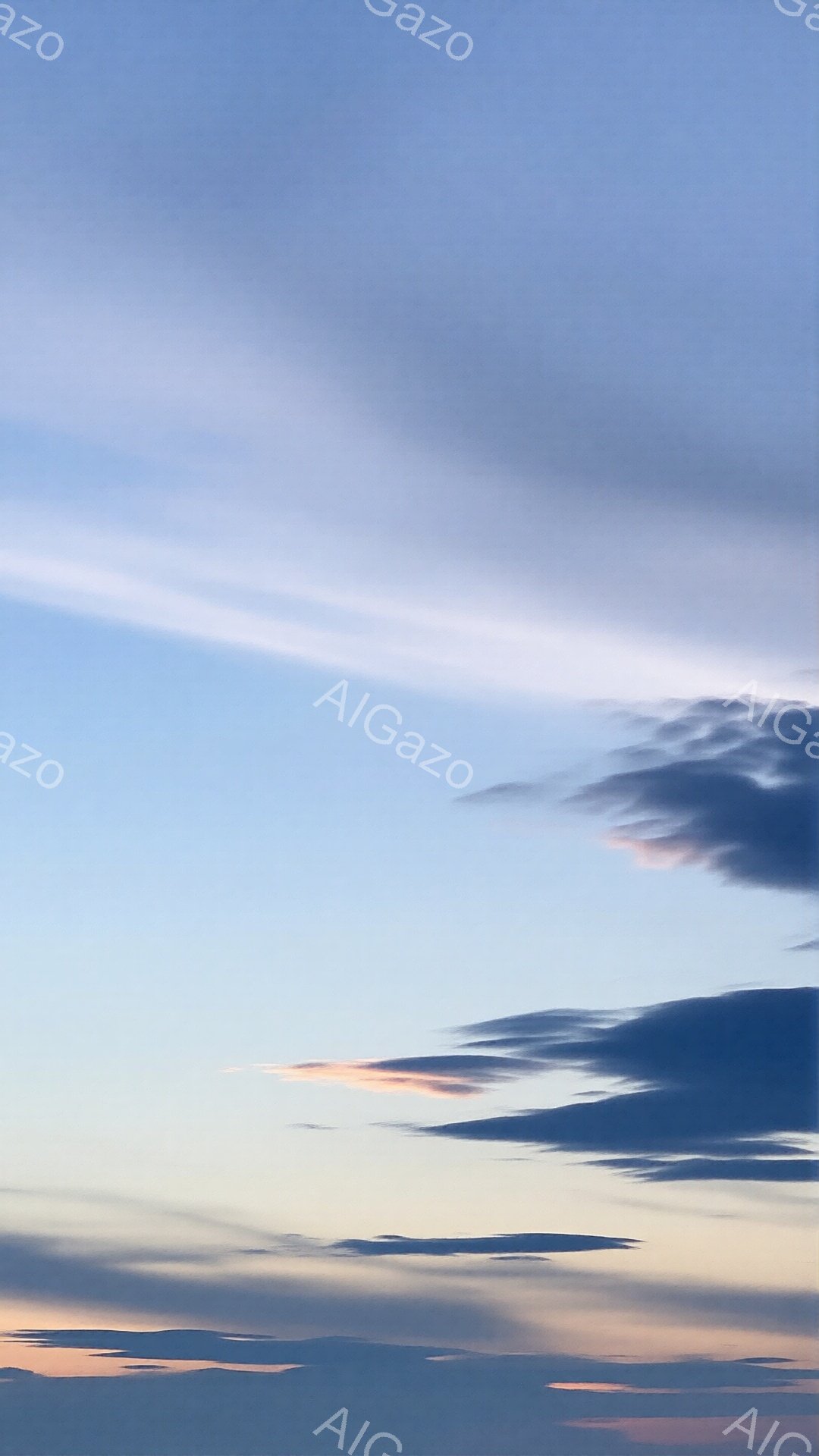 空は薄い青色と淡いピンク色のグラデーションで、雲が点在している。雲は様々な形をしており、夕焼けの光を浴びてオレンジ色やピンク色に染まっている。穏やかで静謐な、平和な雰囲気を感じさせる空の風景だ。 - AI生成フリー素材