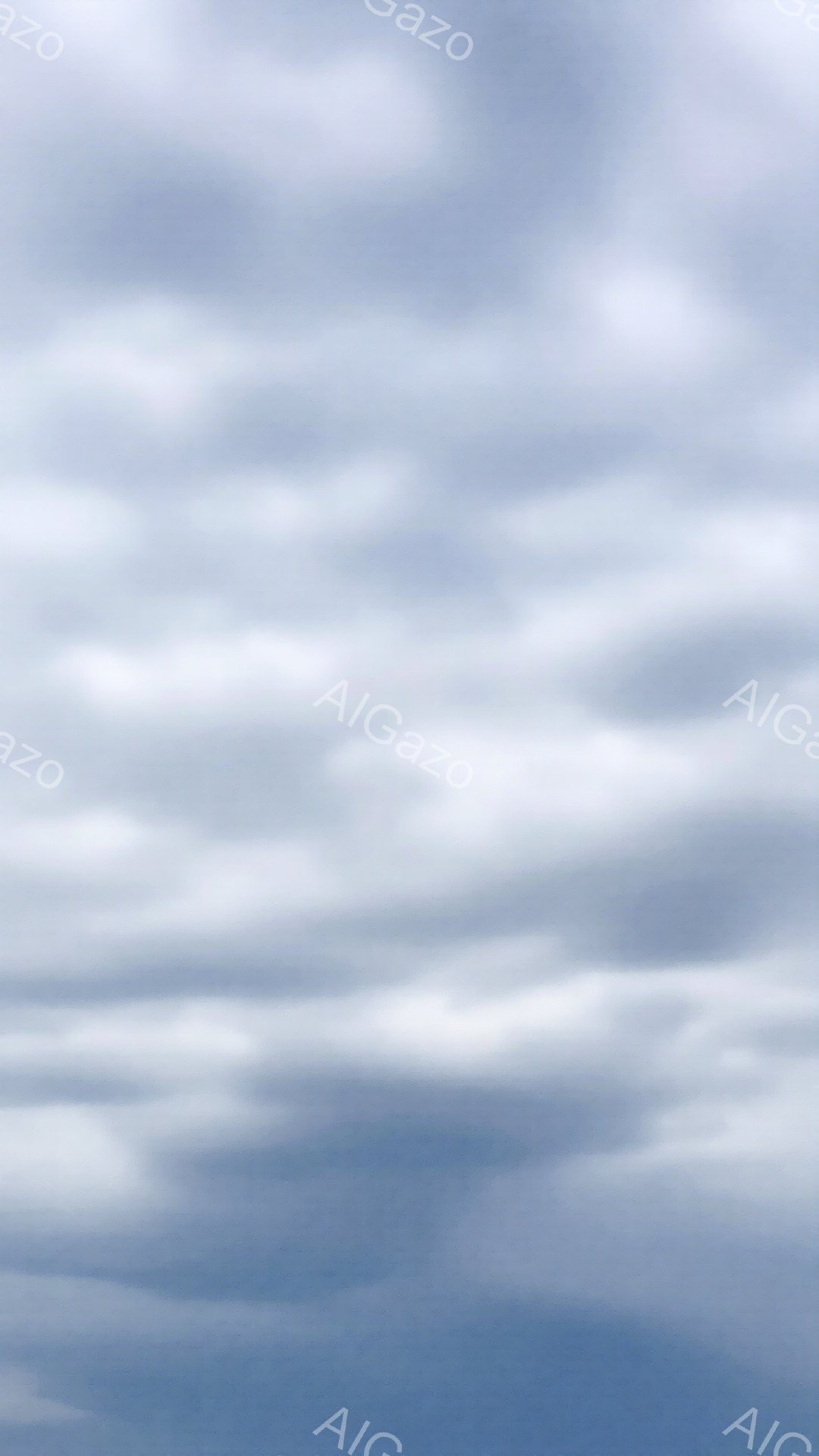 空全体がうねるような白い雲で覆われています。雲は層状になっており、まるで波のような模様を作り出しています。青空が雲の隙間からわずかに見え、穏やかで少し憂鬱な雰囲気を醸し出しています。