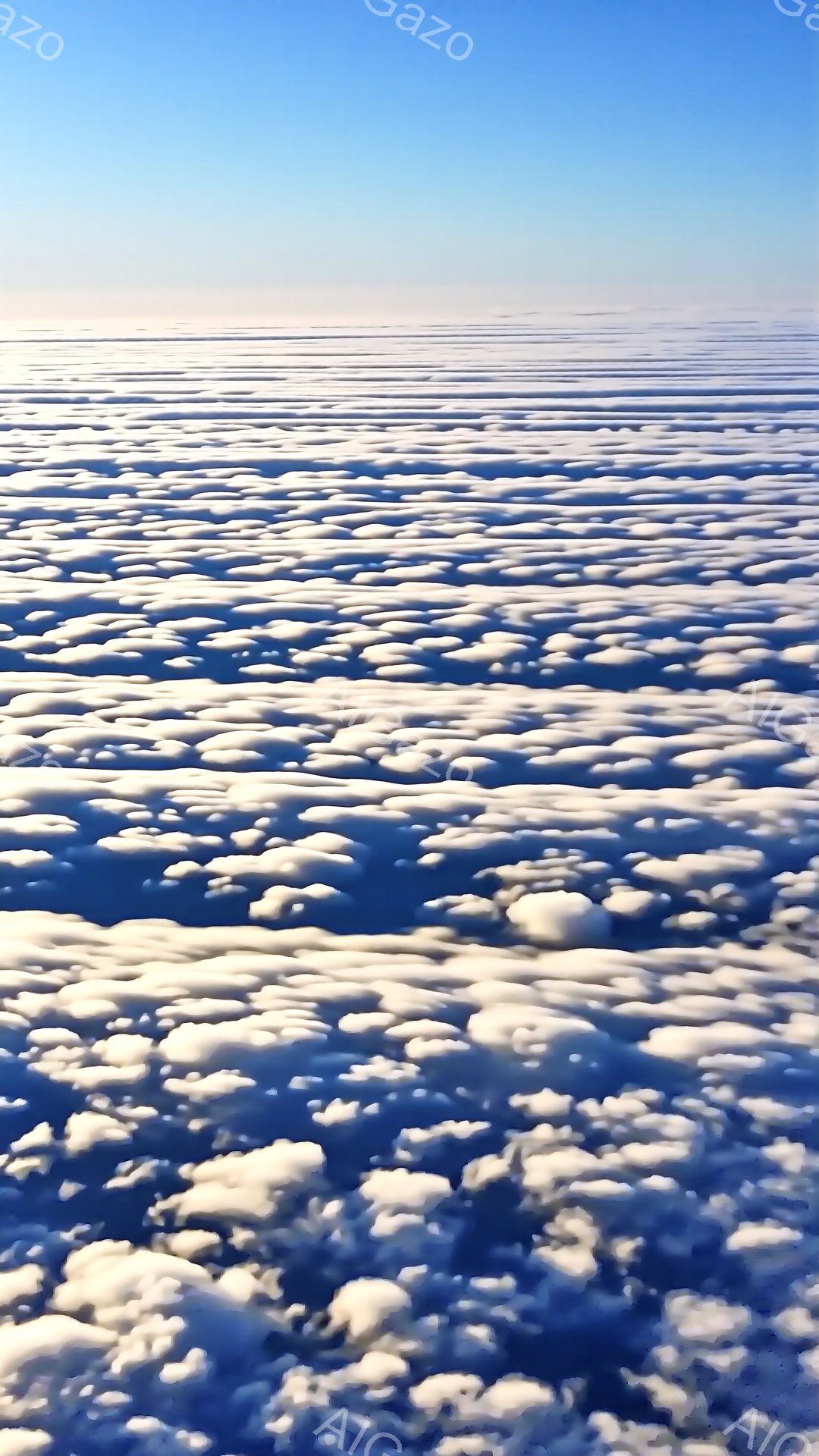広大な空から見下ろした雲海の様子が捉えられています。白い雲がまるで綿のように広がり、地平線まで続く幻想的な光景を作り出しています。青空とのコントラストが美しく、穏やかで静謐な雰囲気が漂います。 - AI生成フリー素材