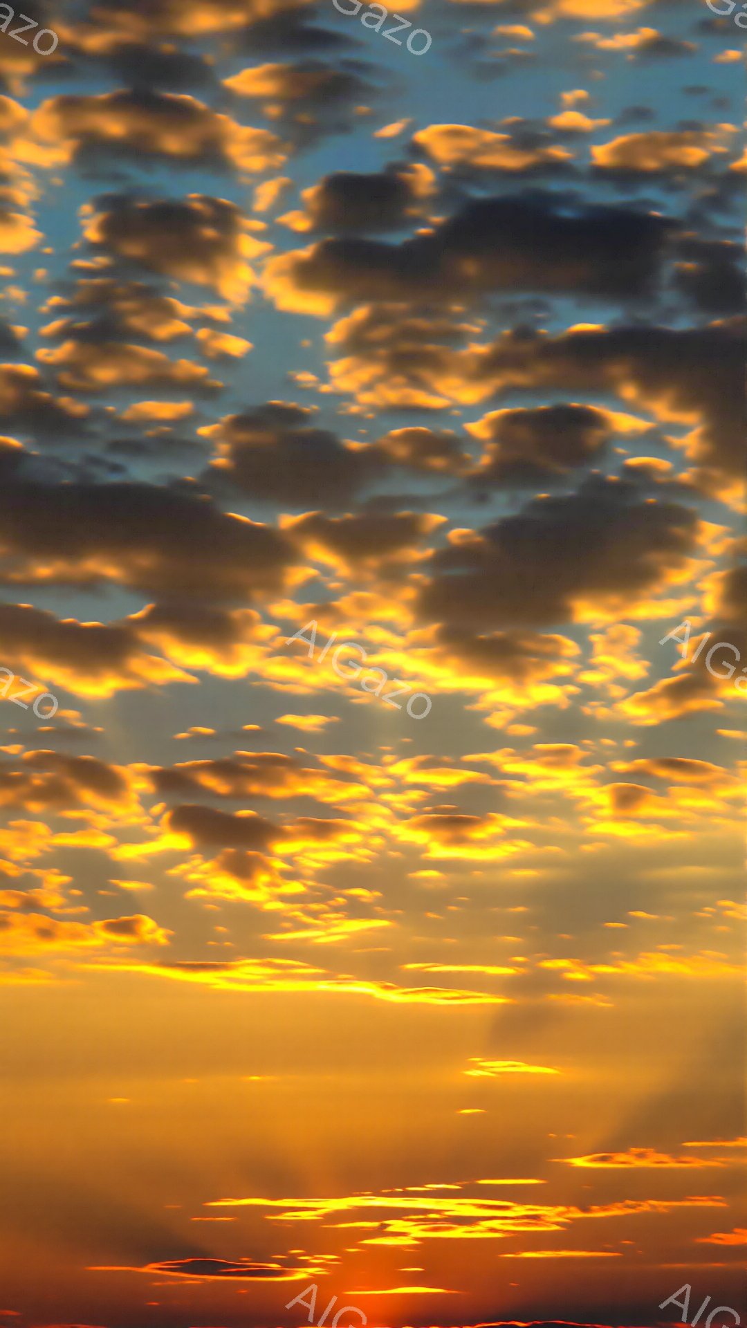 空一面が燃えるようなオレンジと黄色の雲で覆われています。地平線近くでは鮮やかな赤色が雲を照らし、水面にはその光が反射してキラキラと輝いています。全体的に、力強く美しい夕焼けの光景で、暖かくドラマチックな雰囲気を醸し出しています。