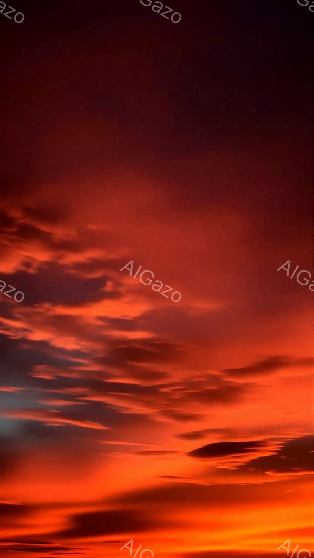 空全体が燃えるような赤とオレンジの色で覆われており、雲が複雑な模様を描き出している。地平線近くは特に明るく、徐々に上空へ向かうにつれて色が濃くなるグラデーションが美しい。強烈な色彩は、まるで世界が炎に包まれようとしているような、劇的で力強い雰囲気を醸し出している。