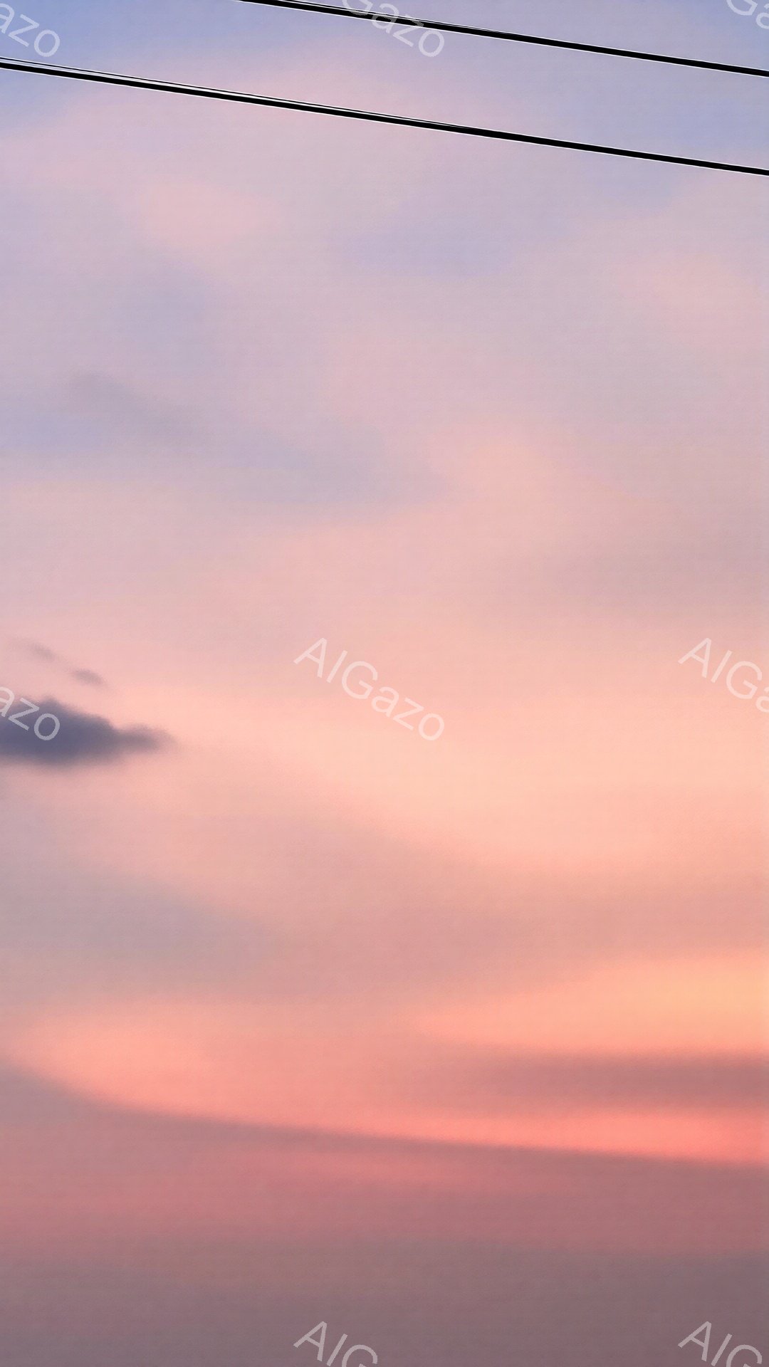 空は夕焼けの名残で、ピンクとオレンジ、そして薄紫が混ざり合い、穏やかなグラデーションを描いている。地平線近くはオレンジ色が濃く、上空へ向かうにつれて淡いピンク色へと変化し、空全体が温かい光に包まれている。数本の電線が画面上部にわずかに写っており、空の美しさを際立たせている。