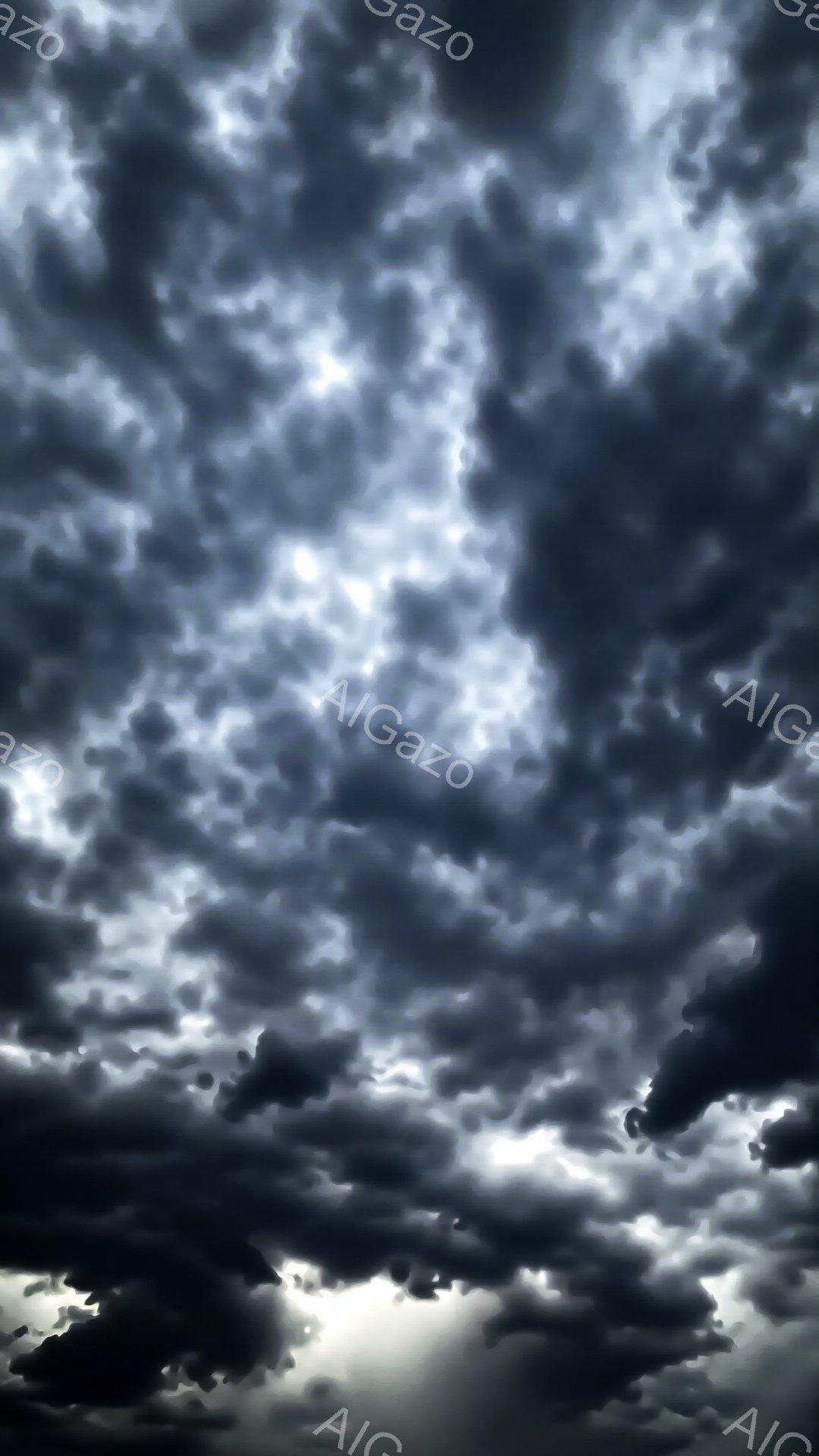 激しい雲が空を覆い尽くし、暗く重苦しい雰囲気を醸し出しています。雲の隙間からわずかに光が差し込み、そのコントラストが不穏な天候を強調しています。まるで嵐が近づいているかのような、緊迫感と威圧感が感じられる空模様です。