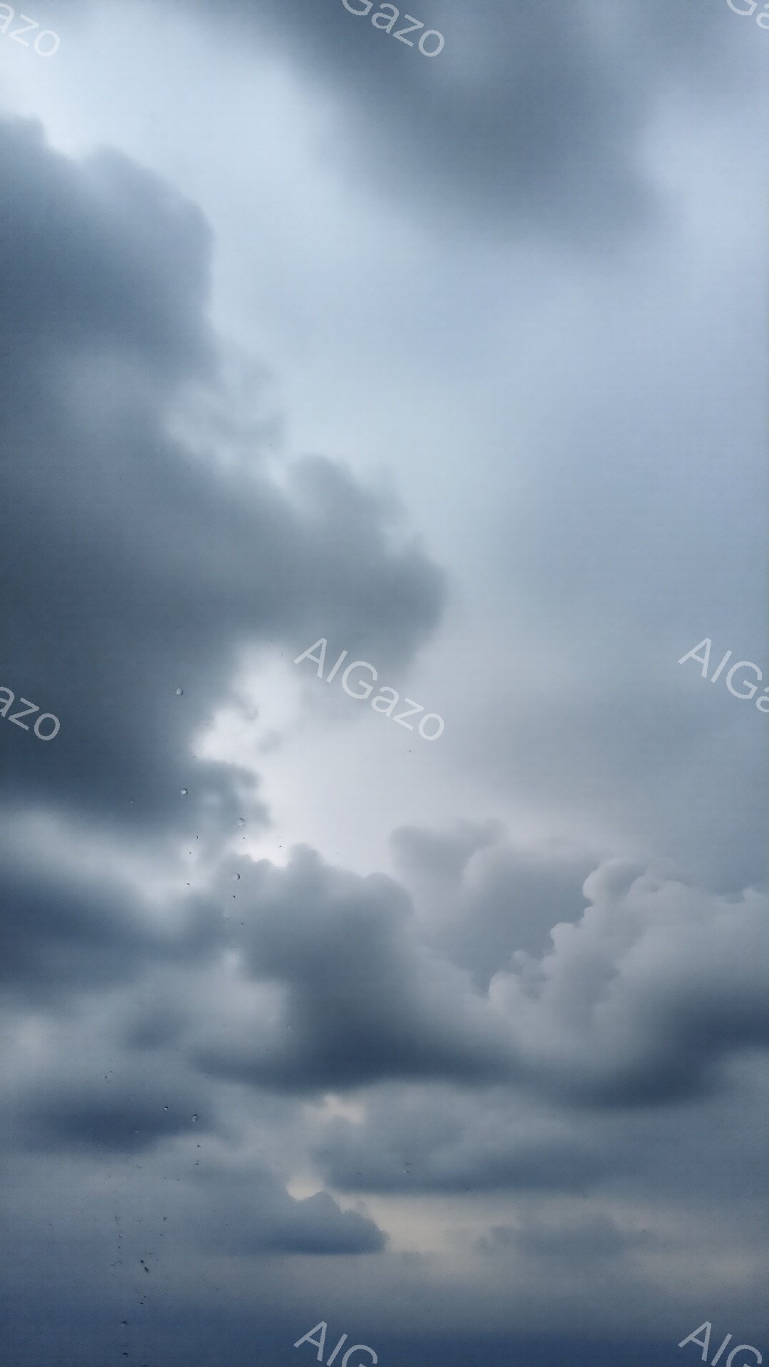 厚い雲が空を覆っており、一部に隙間から淡い光が差し込んでいる。雲は重厚で、まるで嵐の前のように不穏な雰囲気を醸し出している。空には小さな鳥たちが数羽、雲の間を飛んでいるのが見える。