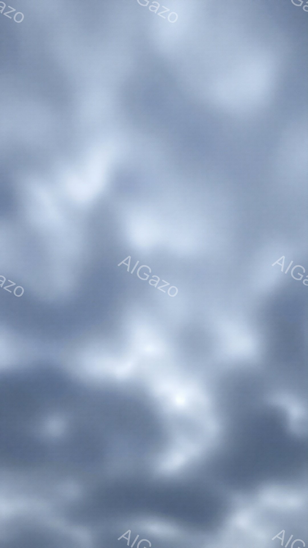 この画像は非常にぼやけており、特定の形や人物を識別することは困難です。全体的に青みがかった灰色で、雲海や霧のような、あるいは水面の反射のようなテクスチャが広がっています。淡い光がかすかに見え、穏やかで幻想的な雰囲気を醸し出しています。