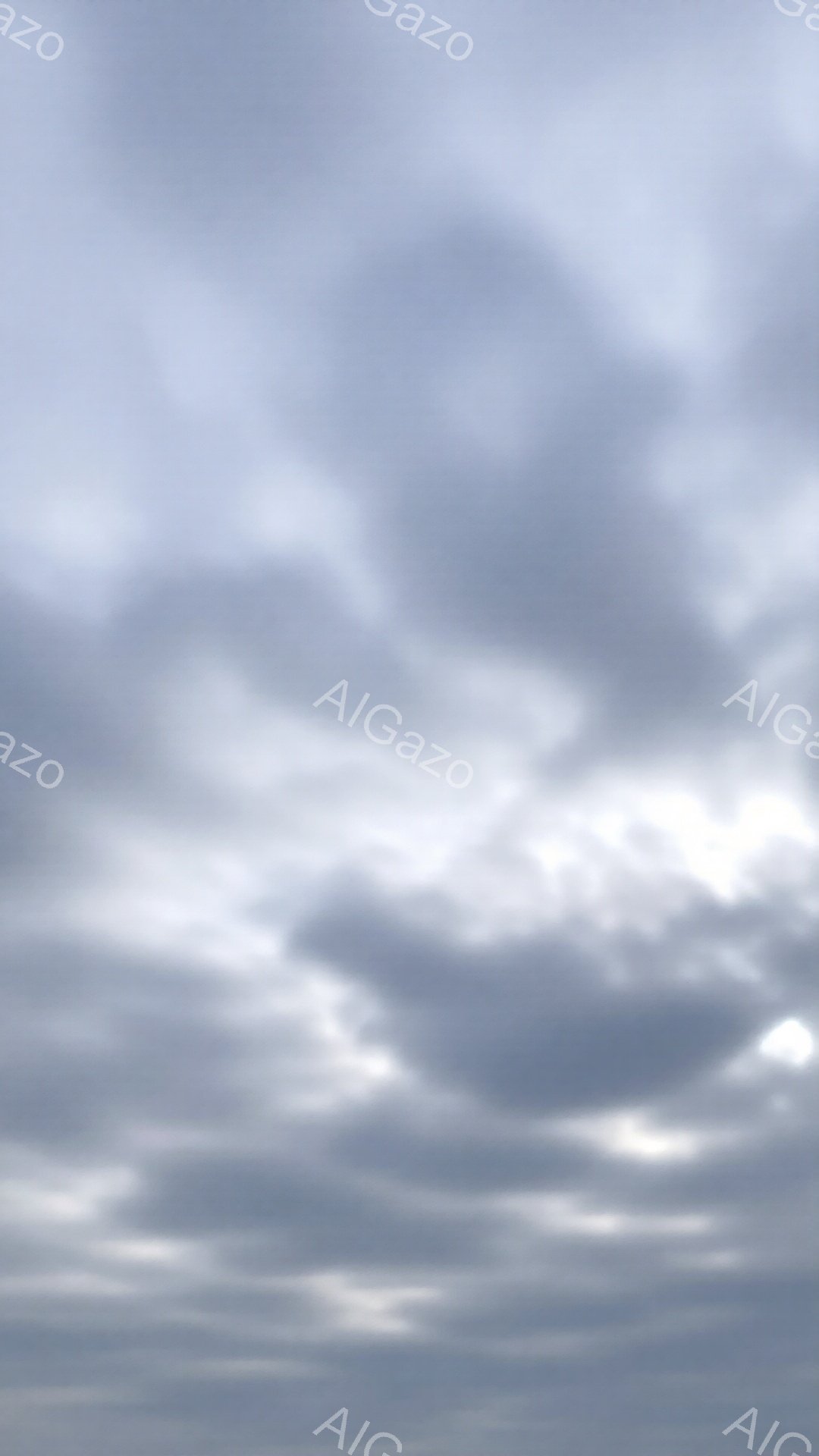 雲が広がる空の画像です。灰色の雲が重なり合い、ところどころに光が差し込んでいます。穏やかで少し憂鬱な雰囲気が漂い、静寂の中に希望の光が感じられます。 - AI生成フリー素材