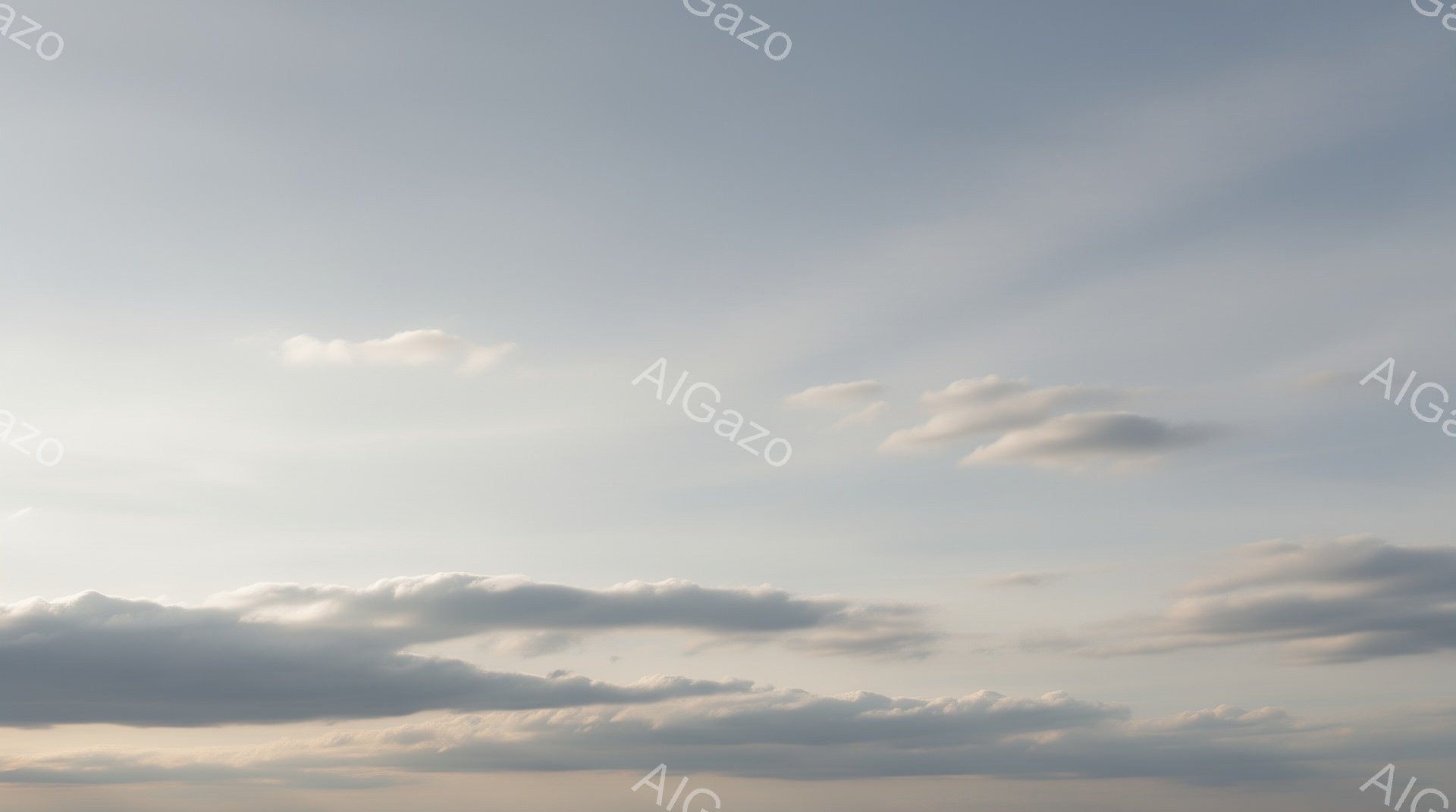 空は薄い青色を背景に、白と灰色の雲が広がっています。雲はさまざまな形をしており、まるで波のように連なっています。全体的に穏やかで、静寂な雰囲気が漂っています。