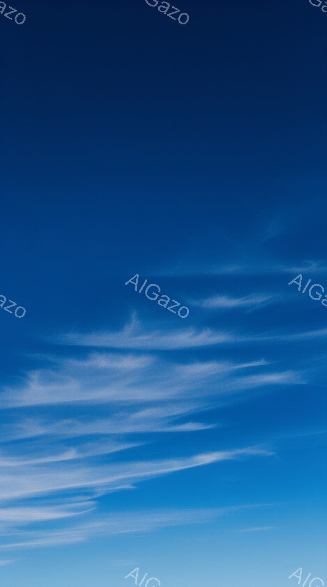 鮮やかな青色の空に、白い筋状の雲が広がり、まるで筆で描いたような繊細な模様を作り出しています。空の下部は薄い水色で、上部へ向かうにつれて深みのある青色へと変化し、グラデーションが美しいです。全体的に穏やかで、開放的な雰囲気を感じさせます。