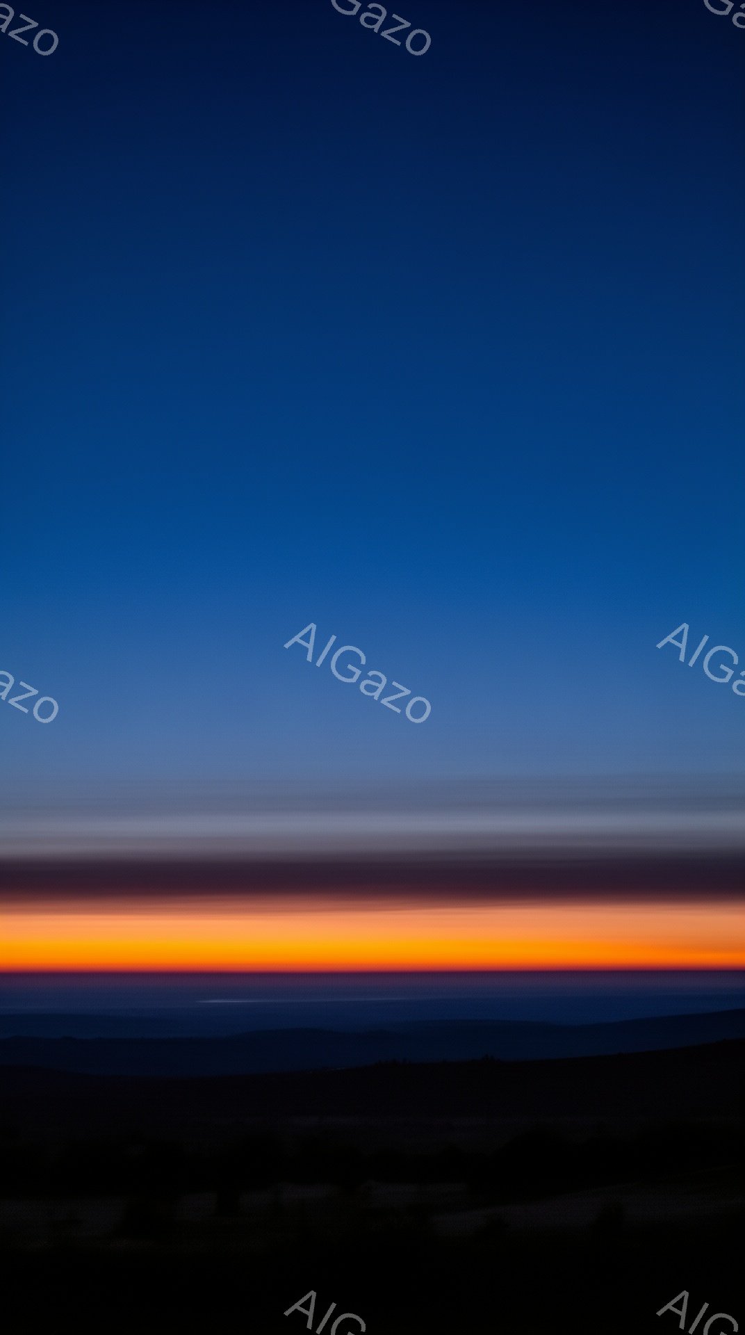 鮮やかなオレンジ色の地平線が、濃い青色の空と緩やかに混ざり合い、美しいグラデーションを生み出している。地平線の下には、暗いシルエットで山並みが連なり、静寂と広大さを感じさせる。 全体的に穏やかで神秘的な雰囲気であり、夕暮れまたは夜明けの美しい自然の光景を捉えた一枚である。
