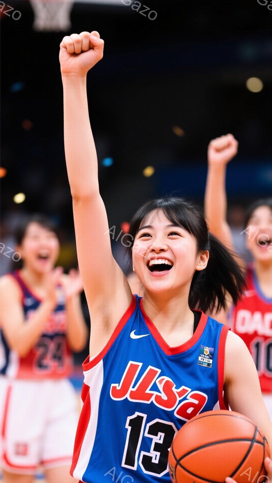 画像は、青と赤のバスケットボールユニフォームを着た若い女性選手が、勝利を喜んで拳を高く上げている様子を捉えています。彼女は黒髪で、満面の笑みを浮かべ、エネルギーに満ち溢れています。背景には、同じユニフォームを着た他の選手たちが喜び、活気のあるバスケットボールの試合の雰囲気が伝わってきます。